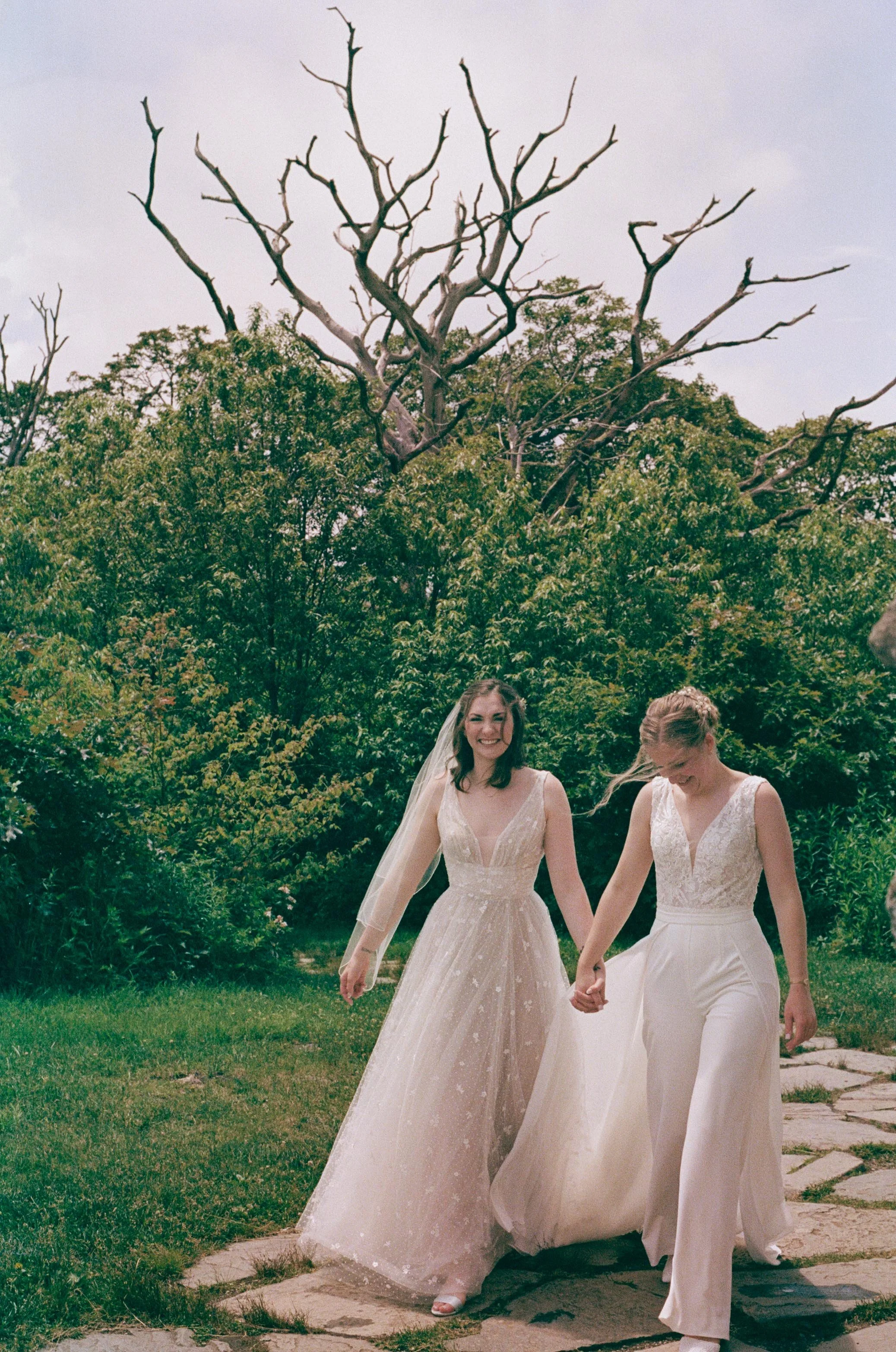 North Carolina film wedding photographer two brides walk along a stone path in Nantahala, North Carolina. Memphis film wedding photographer.