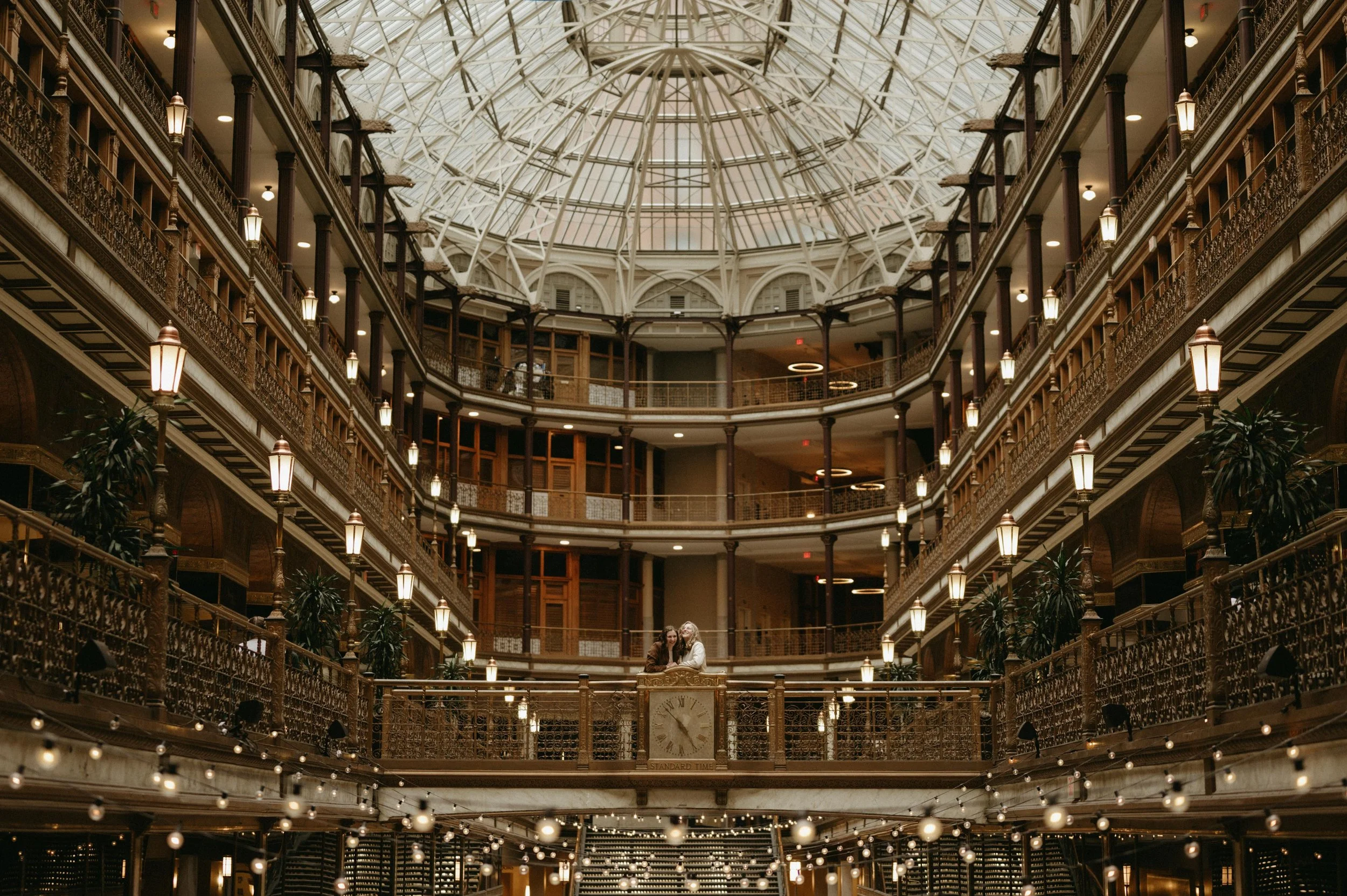 A couple poses on a balcony in the Hyatt Arcade Hotel in downtown Cleveland, Ohio. Moody Memphis wedding photographer. Moody Cleveland wedding photographer. Moody Ohio wedding photographer.