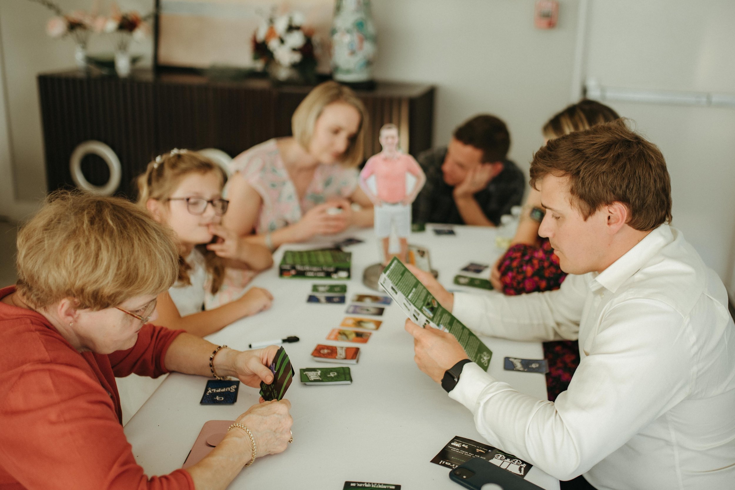 Moody Memphis wedding photographer wedding guests play a board game at a wedding reception. Documentary Memphis Wedding Photographer. Cinematic Memphis wedding photographer.