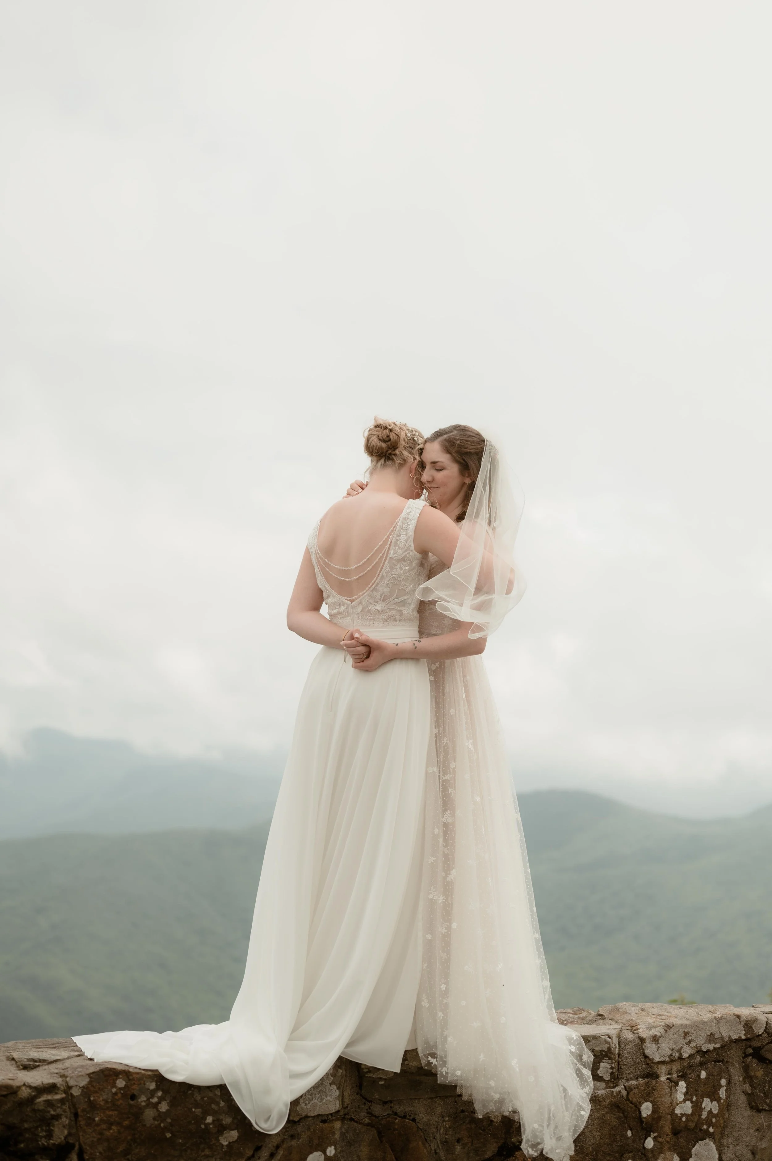 Cinematic North Carolina wedding photography two brides pose overlooking the Appalachian mountains in Nantahala, North Carolina. Cinematic Memphis wedding photographer. Moody Memphis wedding photographer. Moody North Carolina wedding photographer.