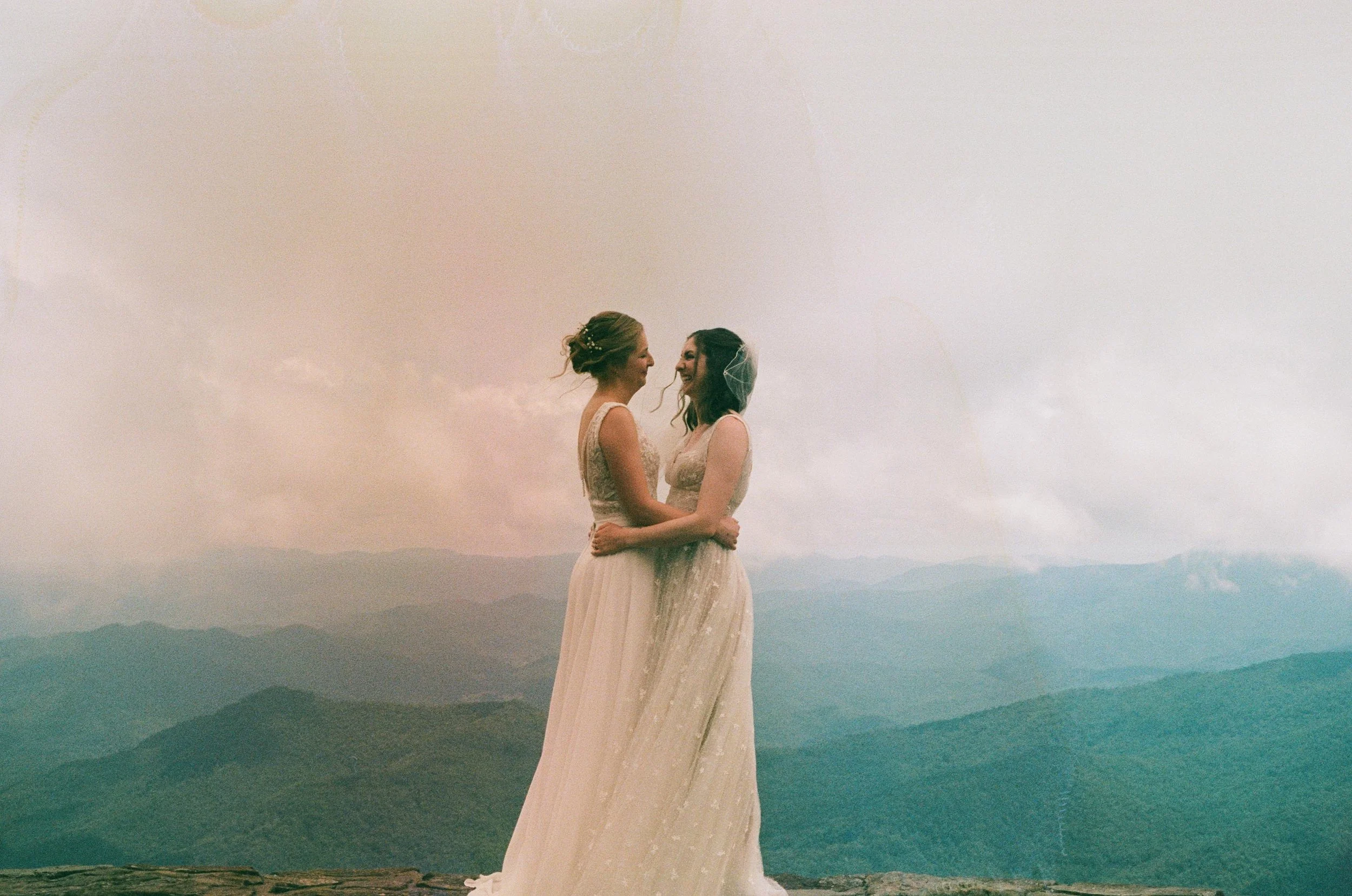 Film wedding photographer two brides embrace on a mountaintop in Nantahala, North Carolina on 35 mm film. Memphis film wedding photographer. North Carolina film wedding photographer. Memphis Documentary wedding photographer.