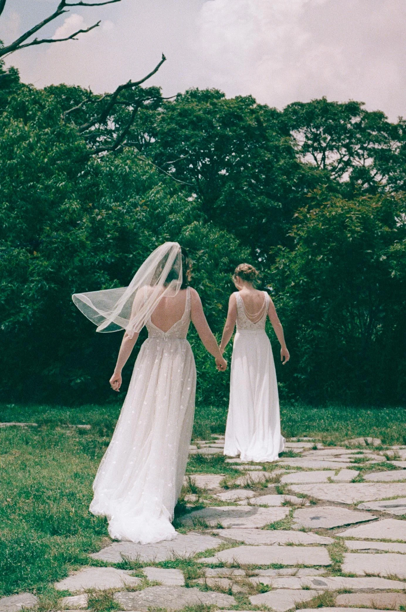 North Carolina film wedding photographer two brides walk along a stone path in Nantahala, North Carolina. Memphis film wedding photographer.