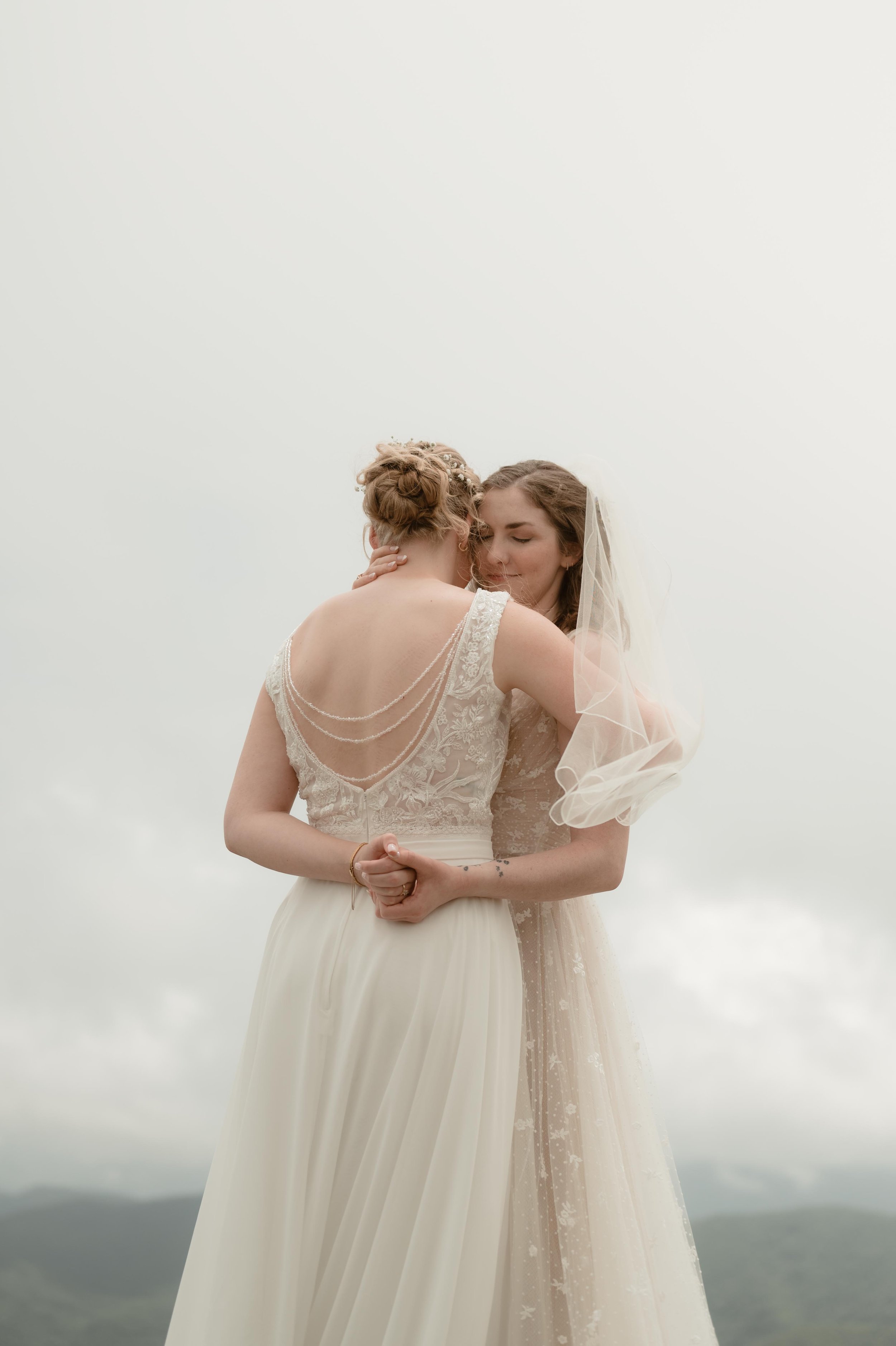 Cinematic North Carolina wedding photography two brides pose overlooking the Appalachian mountains in Nantahala, North Carolina. Cinematic Memphis wedding photographer. Moody Memphis wedding photographer. Moody North Carolina wedding photographer.