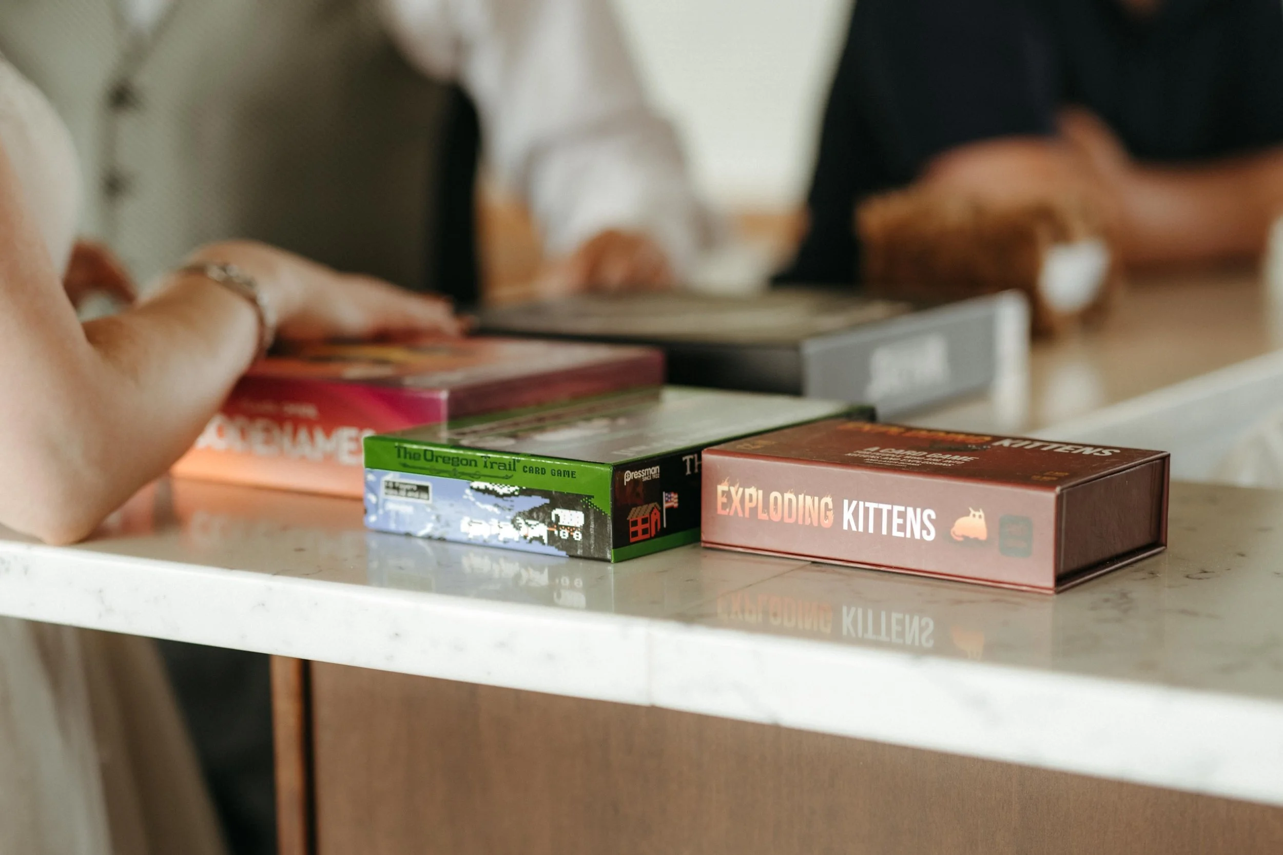 Moody Memphis wedding photographer wedding guests play a board game at a wedding reception. Documentary Memphis Wedding Photographer. Cinematic Memphis wedding photographer.