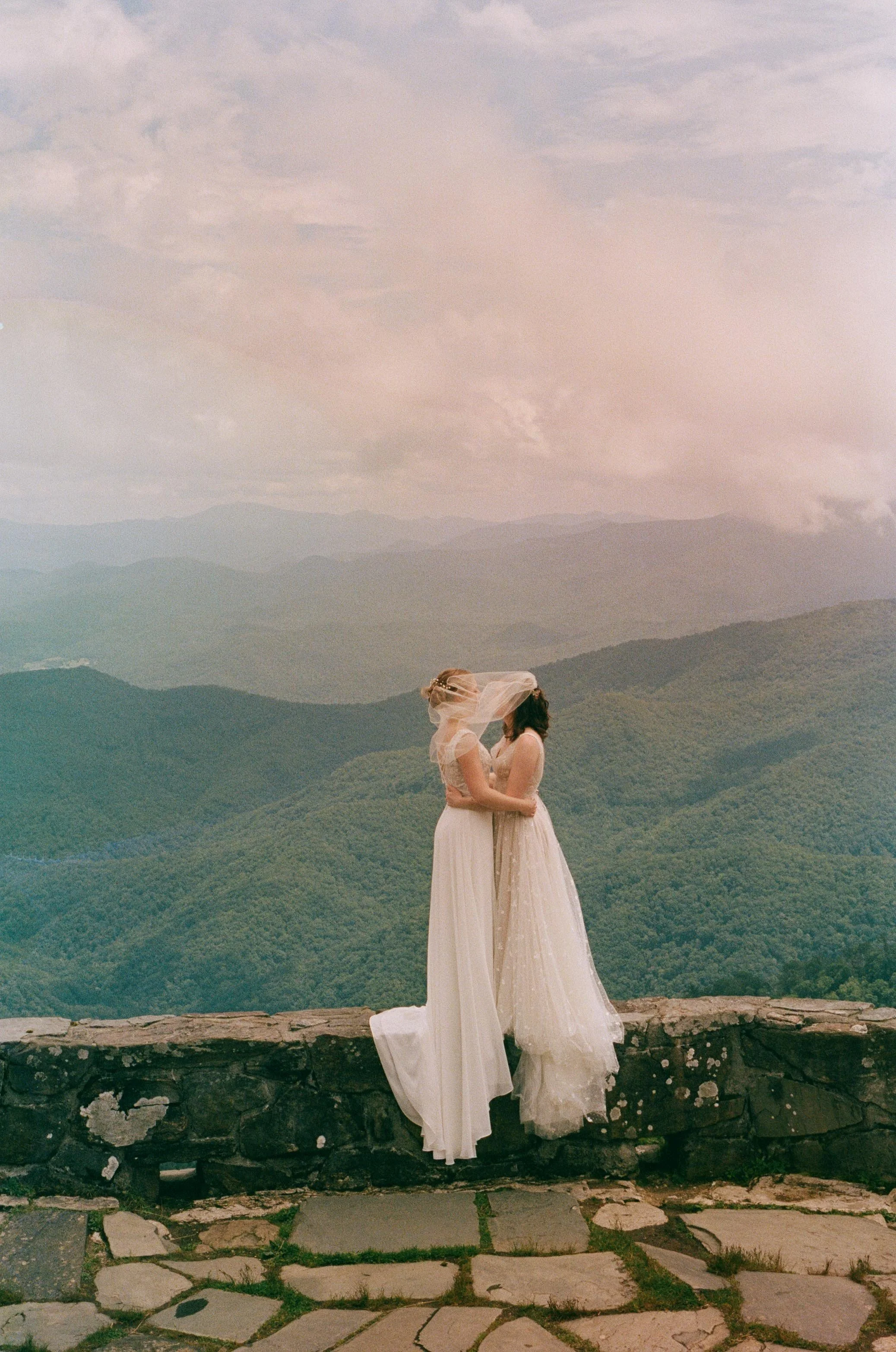 Film wedding photographer two brides embrace on a mountaintop in Nantahala, North Carolina on 35 mm film. Memphis film wedding photographer. North Carolina film wedding photographer. Memphis Documentary wedding photographer.
