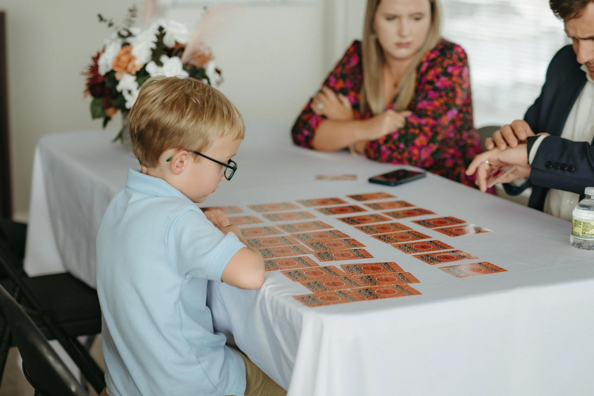 Moody Memphis wedding photographer wedding guests play a board game at a wedding reception. Documentary Memphis Wedding Photographer. Cinematic Memphis wedding photographer.