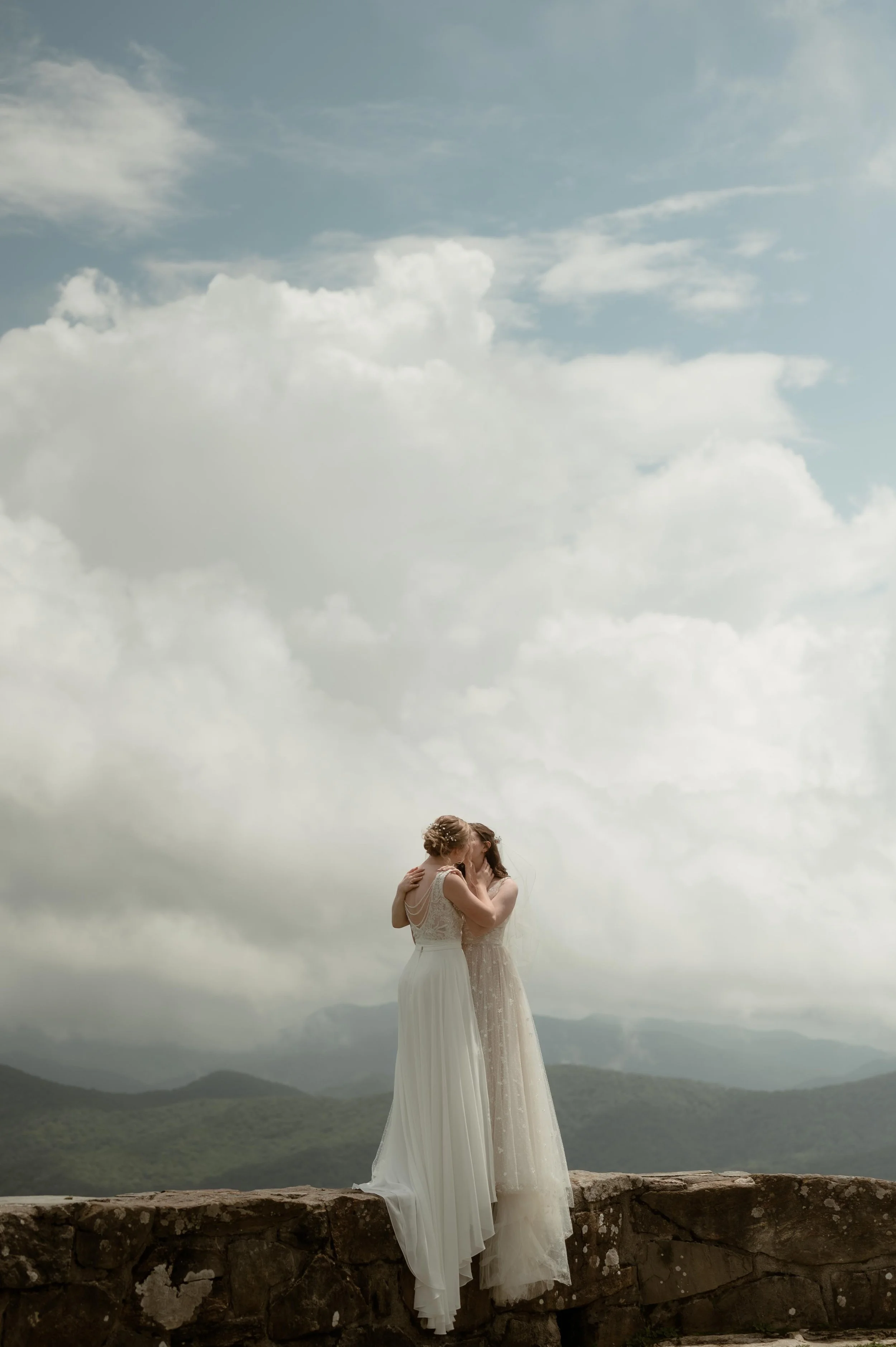 Cinematic North Carolina wedding photography two brides pose overlooking the Appalachian mountains in Nantahala, North Carolina. Cinematic Memphis wedding photographer. Moody Memphis wedding photographer. Moody North Carolina wedding photographer.