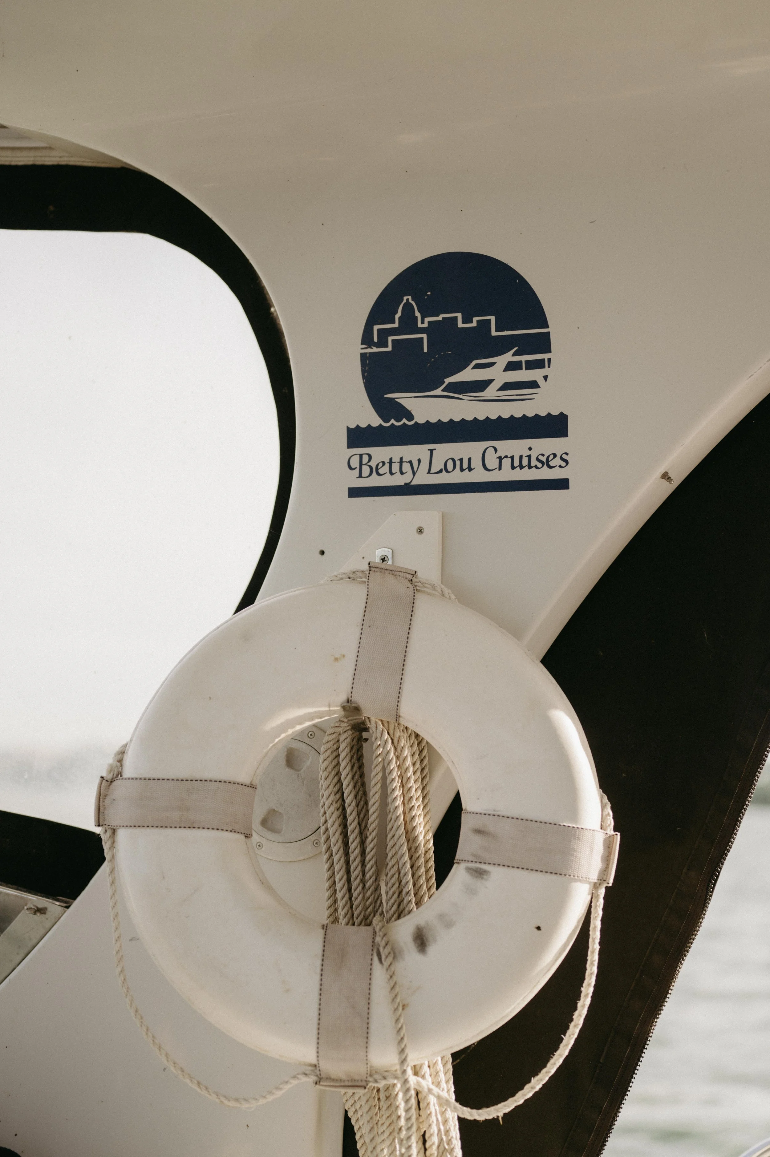 Picture of the interior of a yacht with the Betty Lou Cruises Logo and a white life preserver. Moody Madison wedding photographer. Documentary Madison wedding photographer.