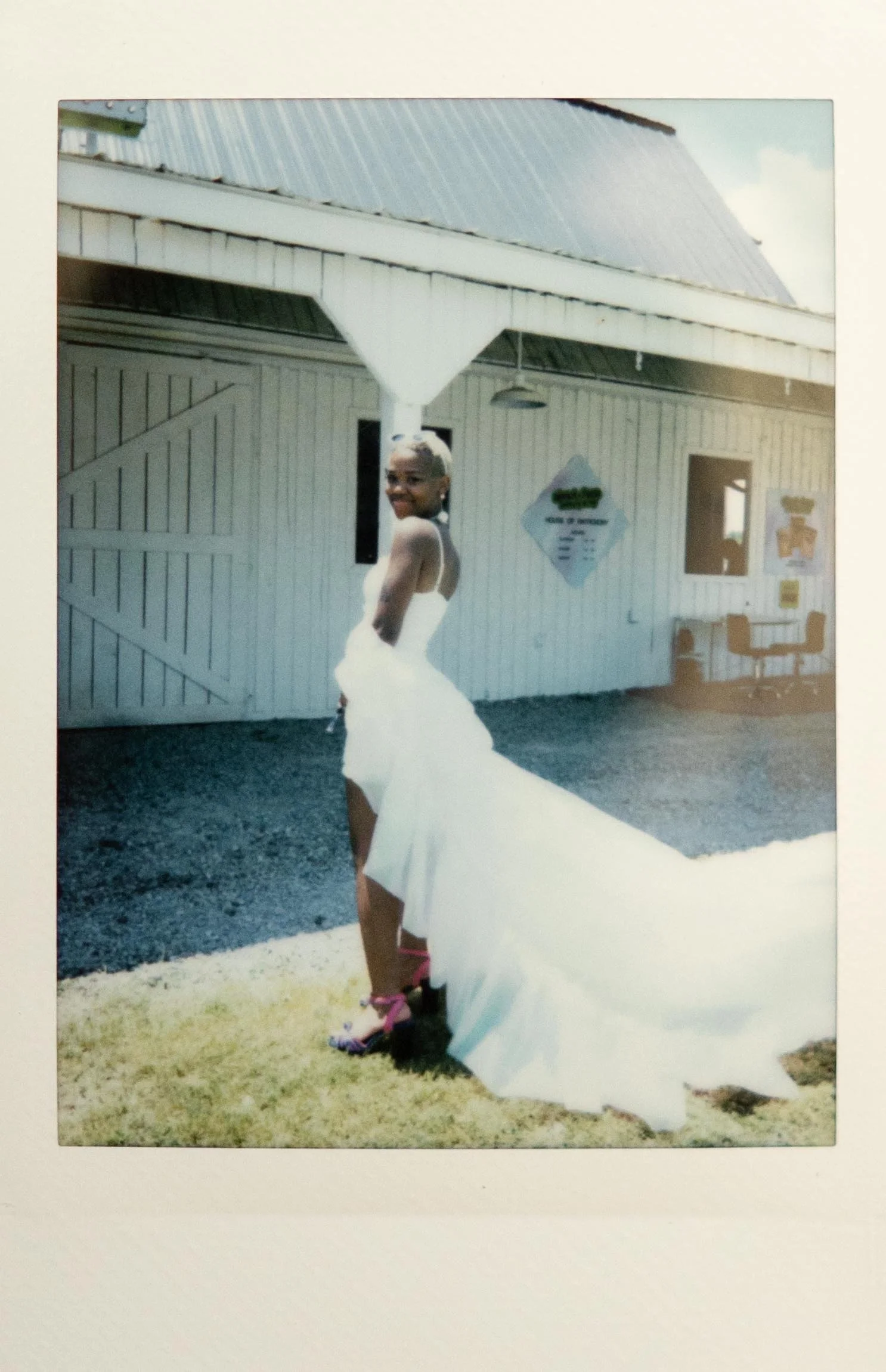 Instant film polaroid elopement photography a bride poses in a white mini dress and long white cape in front of the wedding chapel at Bonnaroo. Moody Nashville wedding photographer. Nashville film wedding photographer.