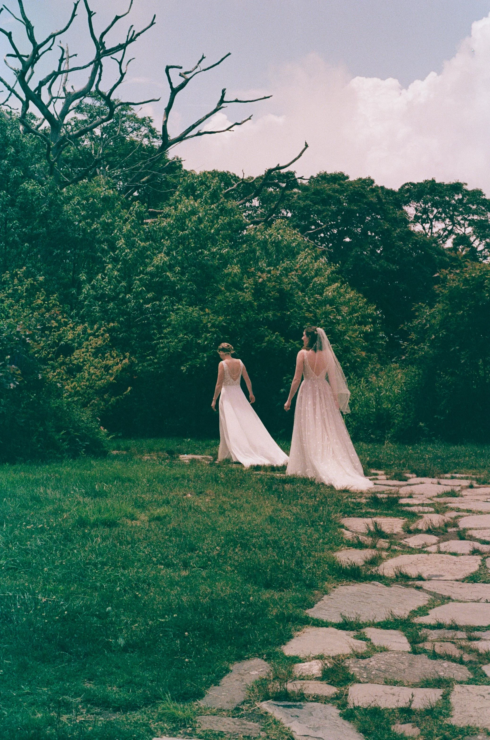 North Carolina film wedding photographer two brides walk along a stone path in Nantahala, North Carolina. Memphis film wedding photographer.
