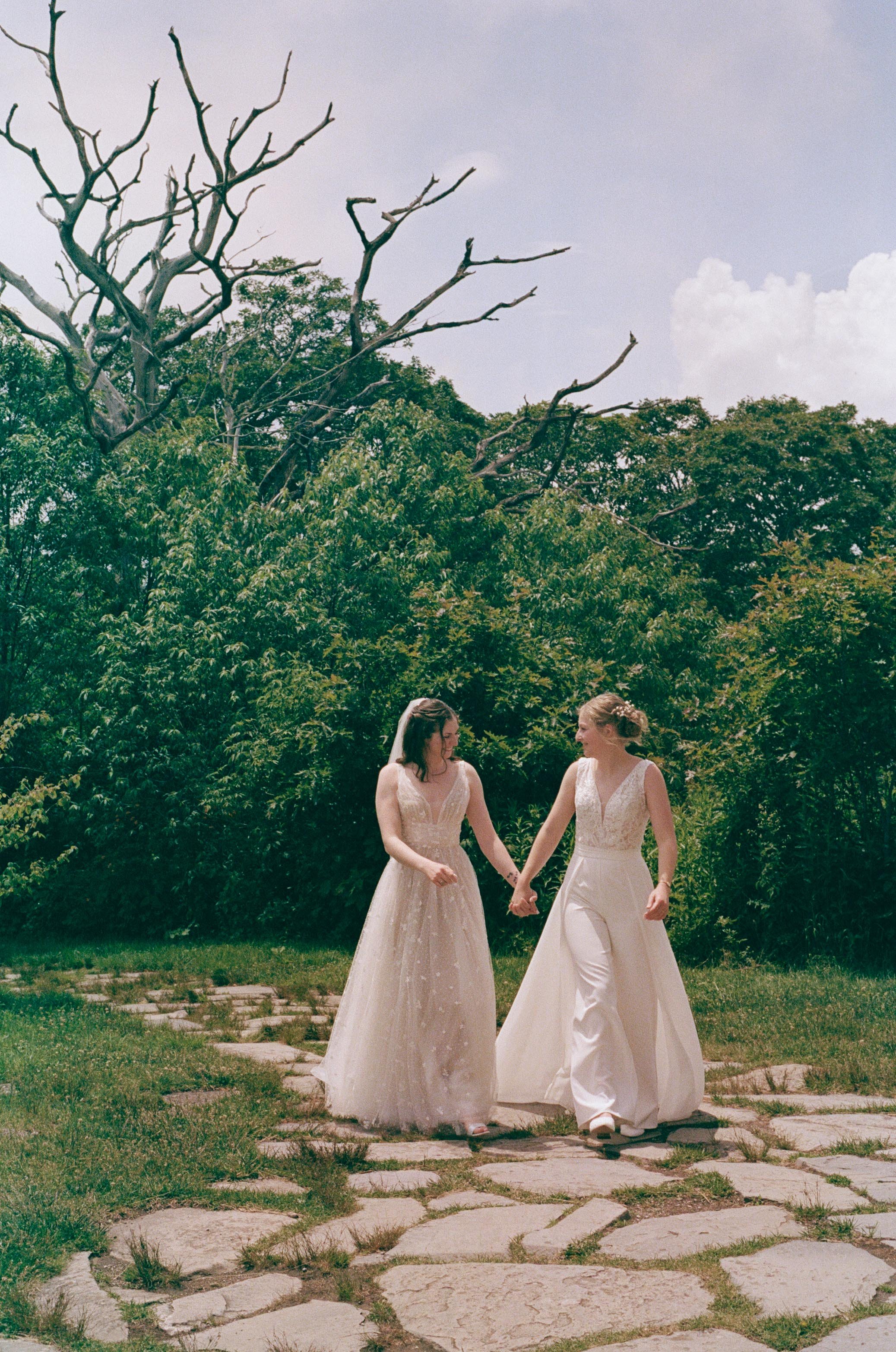North Carolina film wedding photographer two brides walk along a stone path in Nantahala, North Carolina. Memphis film wedding photographer.