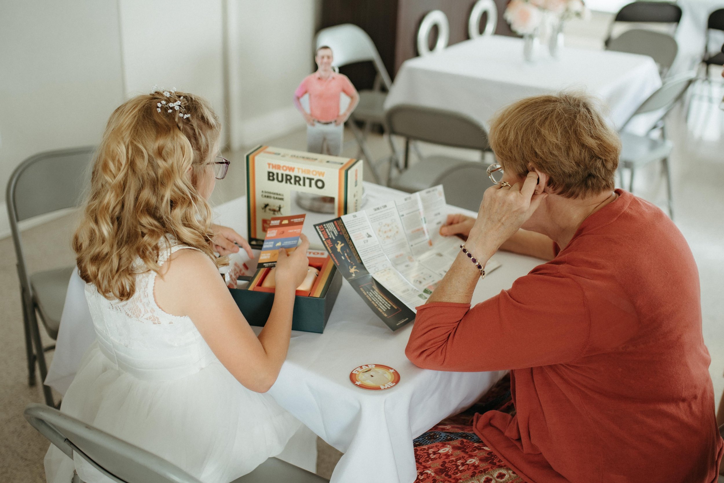 Moody Memphis wedding photographer wedding guests play a board game at a wedding reception. Documentary Memphis Wedding Photographer. Cinematic Memphis wedding photographer.