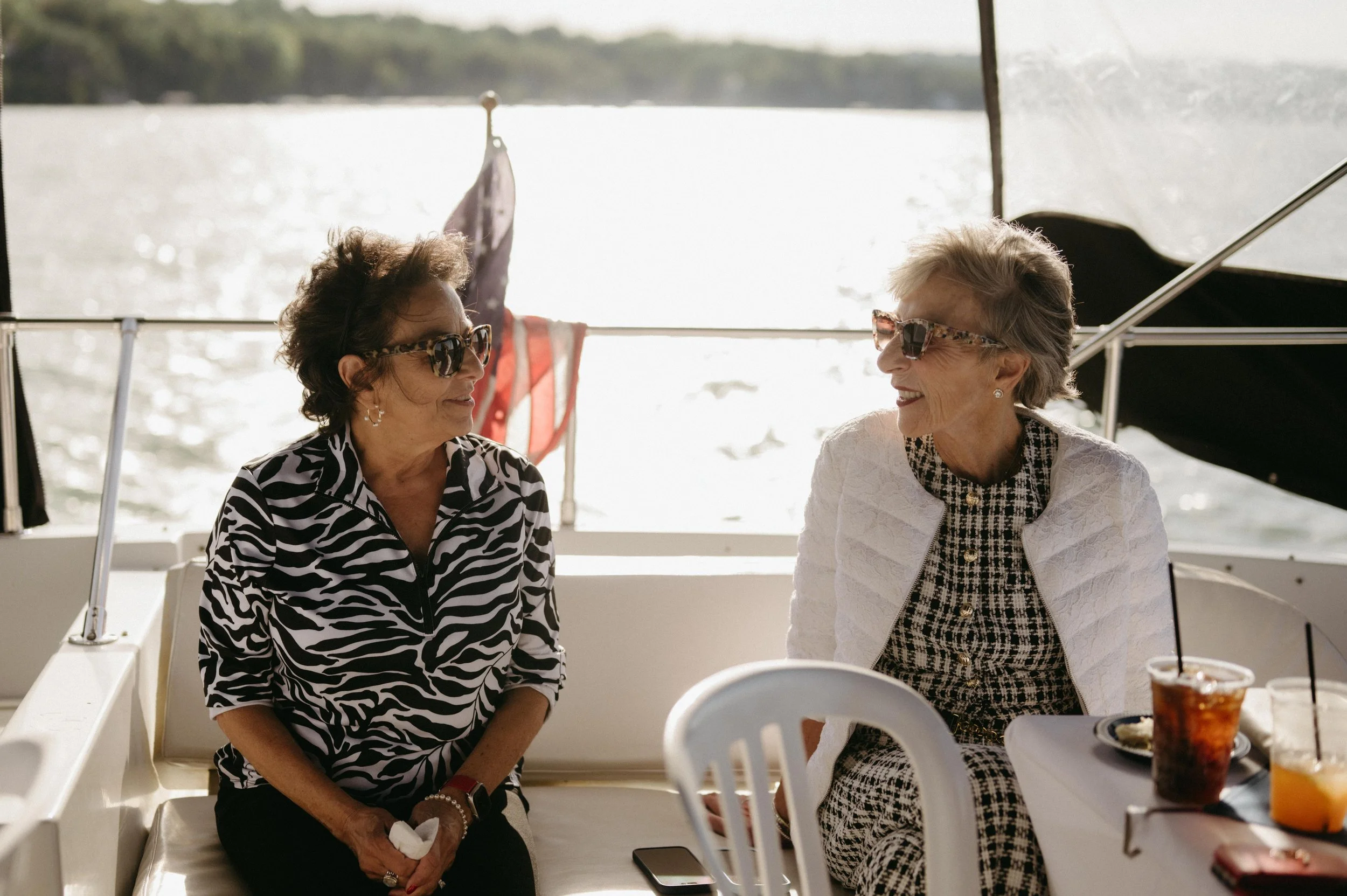 Wedding guests relax on a yacht during a welcome dinner cruise on Lake Mendota in Madison, Wisconsin. Moody Madison wedding photographer. Documentary Madison wedding photographer.