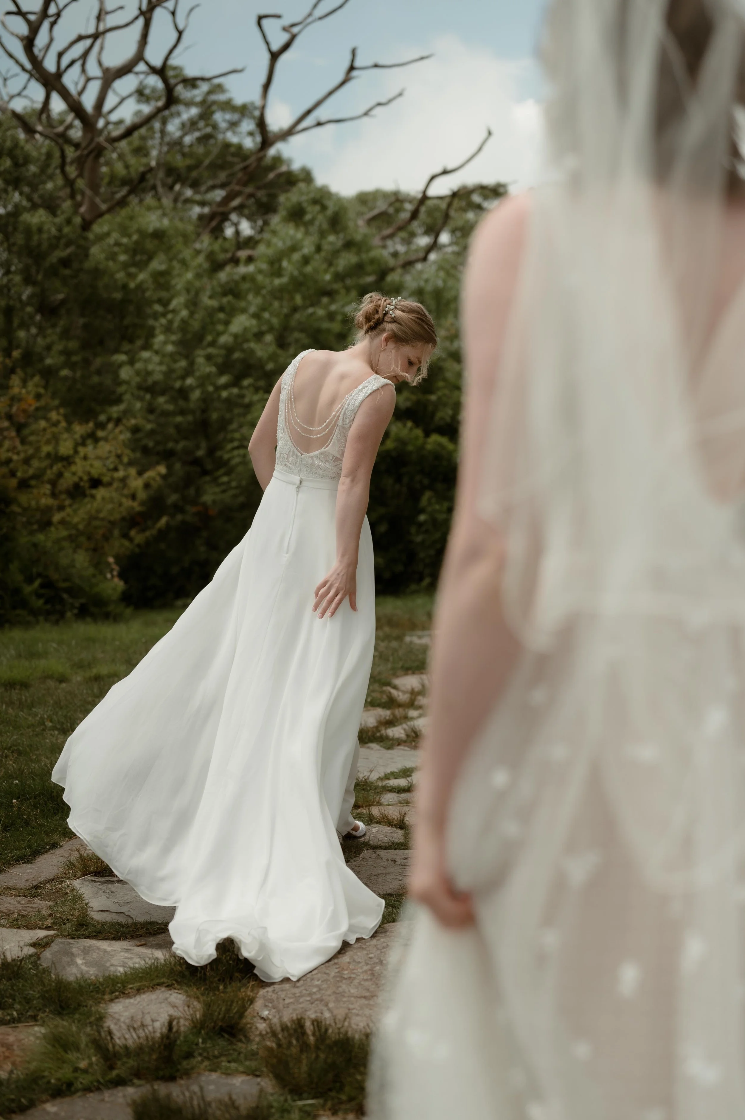 Cinematic North Carolina wedding photographer two brides walk along a stone path in Nantahala, North Carolina. Cinematic Memphis wedding photographer. Moody Memphis wedding photographer. Moody North Carolina wedding photographer.