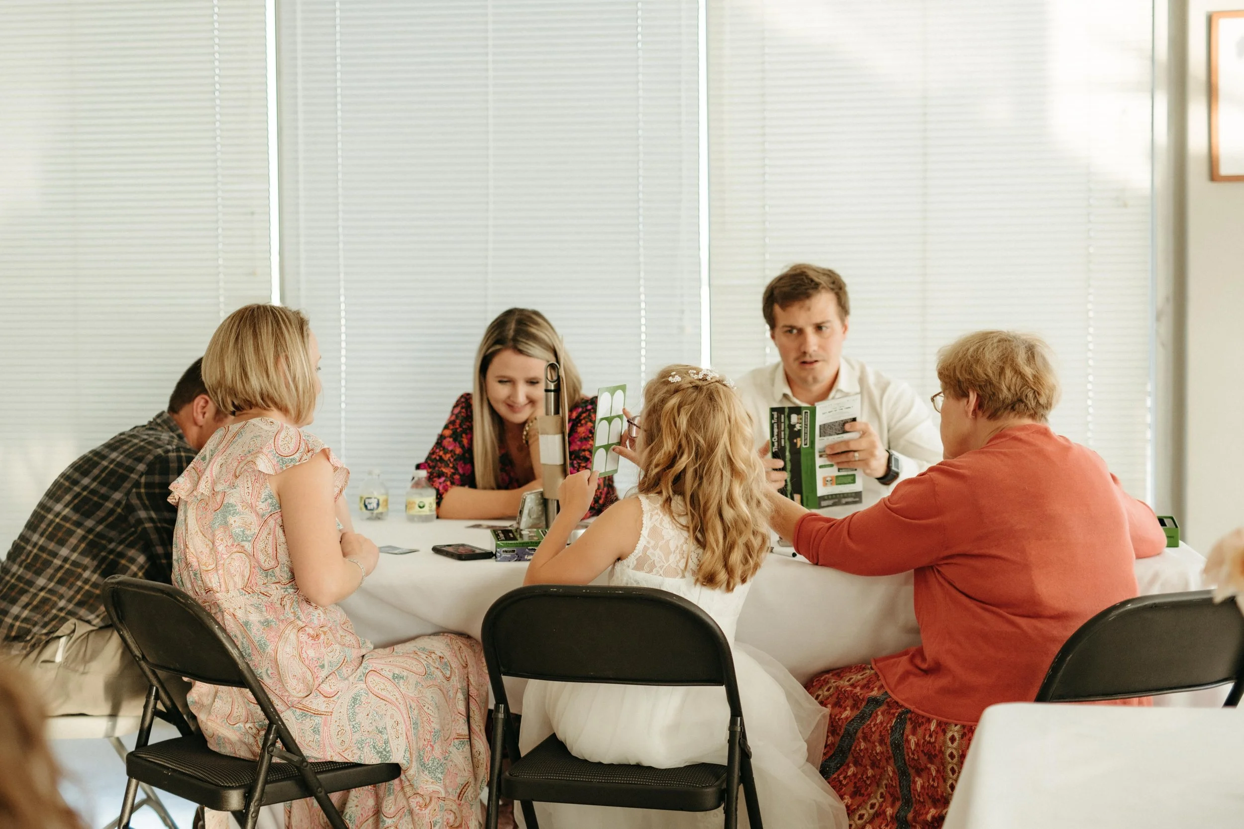 Moody Memphis wedding photographer wedding guests play a board game at a wedding reception. Documentary Memphis Wedding Photographer. Cinematic Memphis wedding photographer.