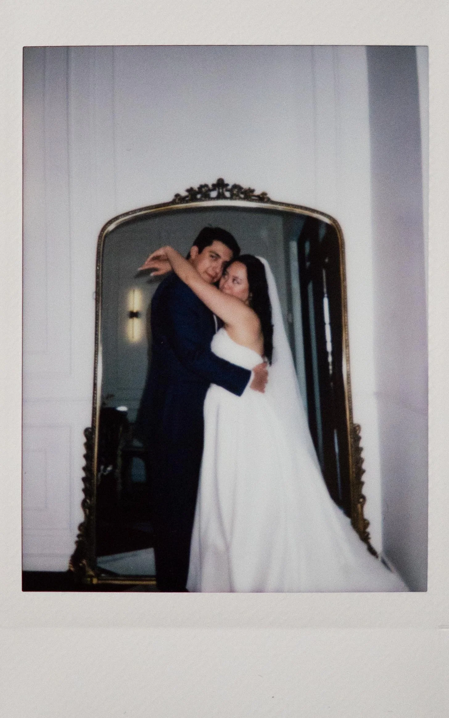 Moody wedding photography a bride and groom pose in front of a large golden mirror in the Parisian in Huntsville, Alabama. Moody Huntsville wedding photographer. Documentary Huntsville wedding photographer. Polaroid Huntsville wedding photographer.