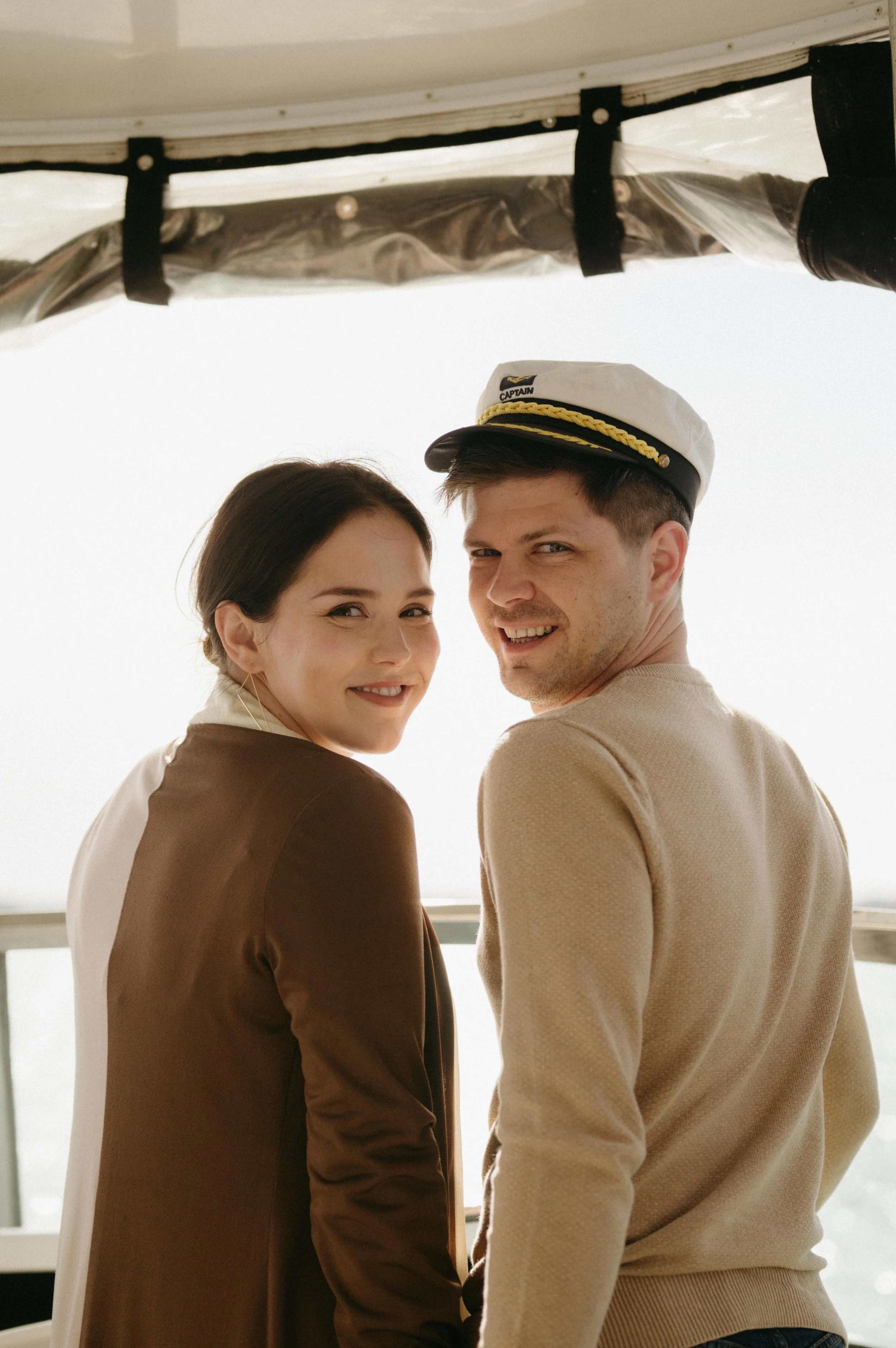 A bride and groom posing for a photo on a rehearsal dinner cruise on Lake Mendota, Madison Wisconsin. Moody Madison wedding photographer.