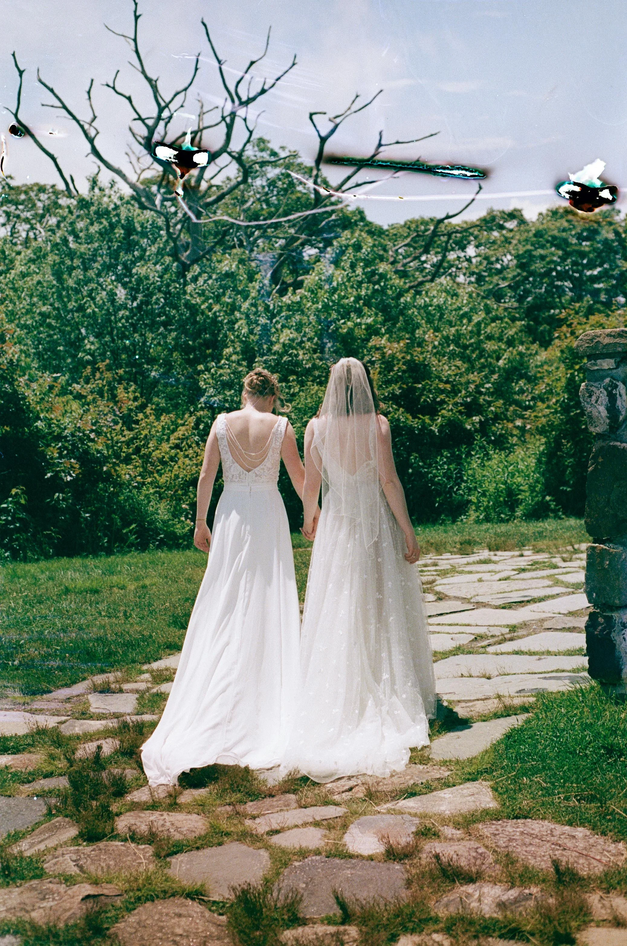 North Carolina film wedding photographer two brides walk along a stone path in Nantahala, North Carolina. Memphis film wedding photographer.