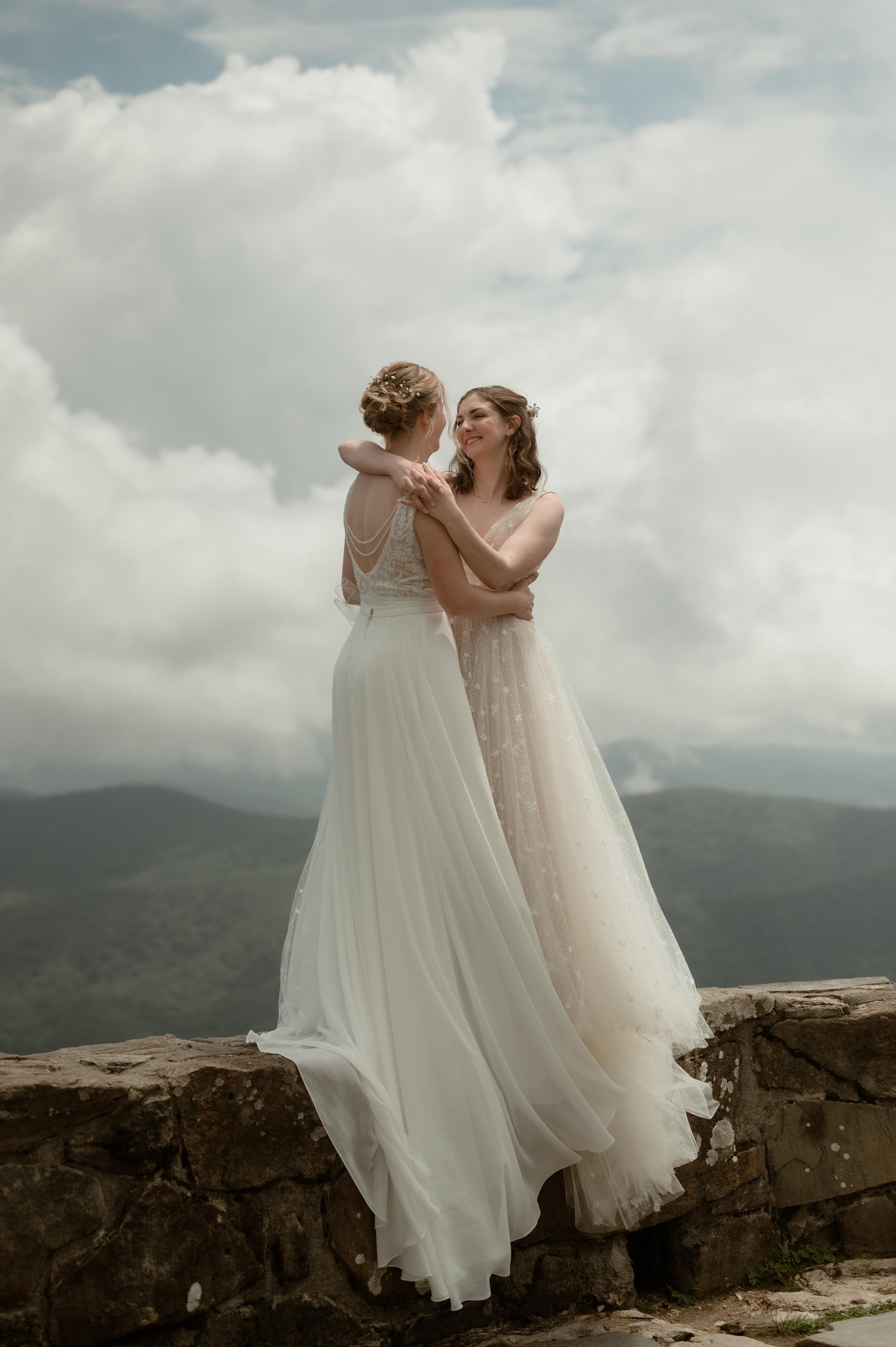 Cinematic North Carolina wedding photography two brides pose overlooking the Appalachian mountains in Nantahala, North Carolina. Cinematic Memphis wedding photographer. Moody Memphis wedding photographer. Moody North Carolina wedding photographer.