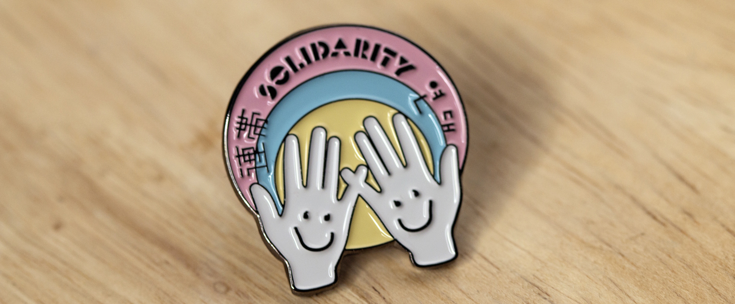 明日少女隊 連帯ピンバッジ:Solidarityとは、日本語では連帯と訳され、力を合わせるという意味です。今回のプロジェクトでは、国境や世代を超えて連帯(solidarity)を呼びかけることを目的としているので、このモチーフのバッジを作りました!日本語、英語、韓国語での表記となっています。