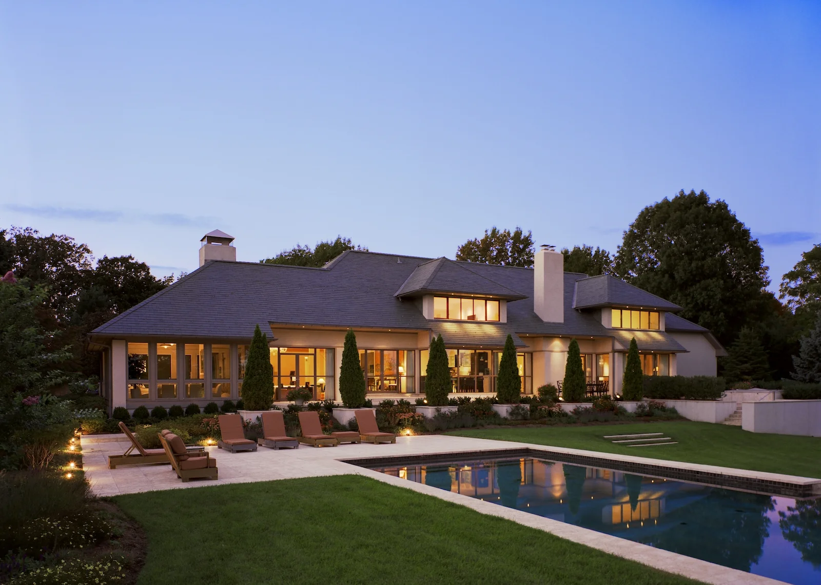 long rectangular pool with comfortable lounge seats infront of house.jpg