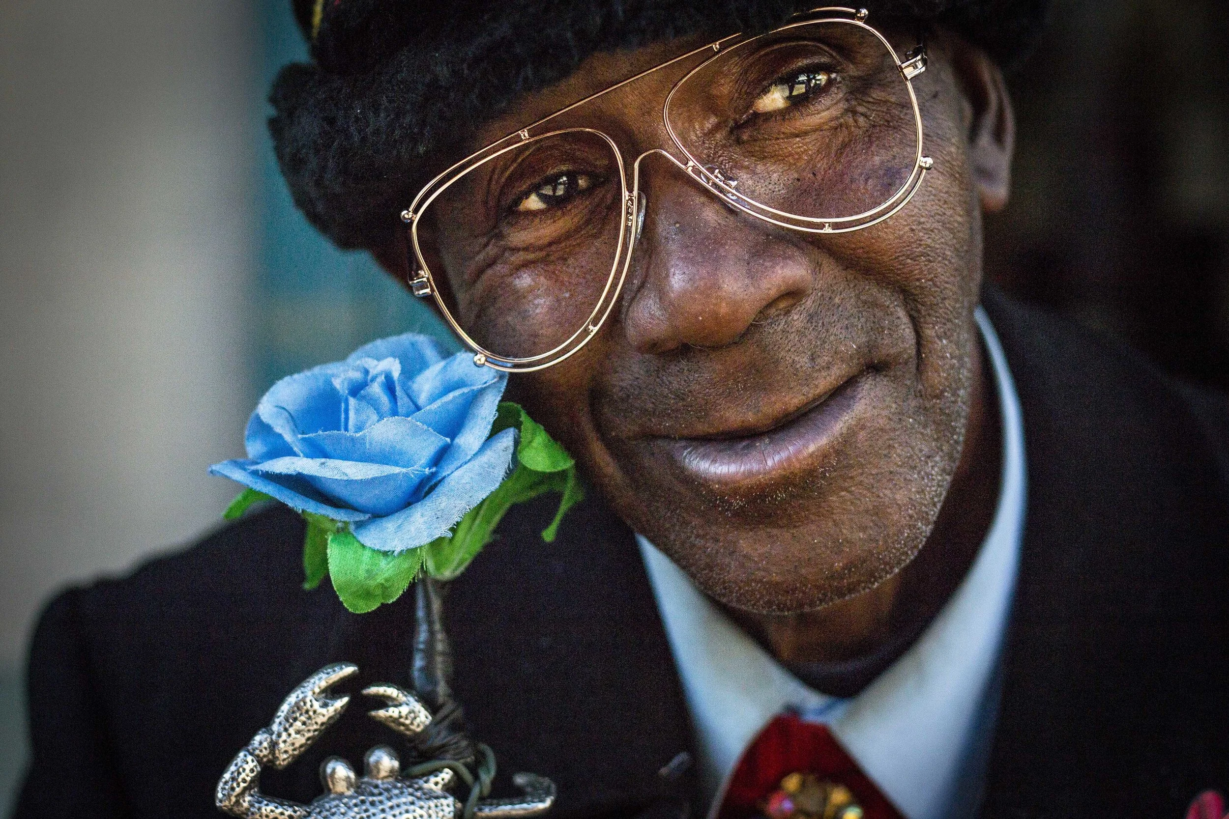 Sitting on a New Orleans stoop and resting on a cane, wrapped with a blue flower and topped with a sliver crab, Chester talks about growing up on Bourbon Street, Nov. 26, in New Orleans, Louisiana.