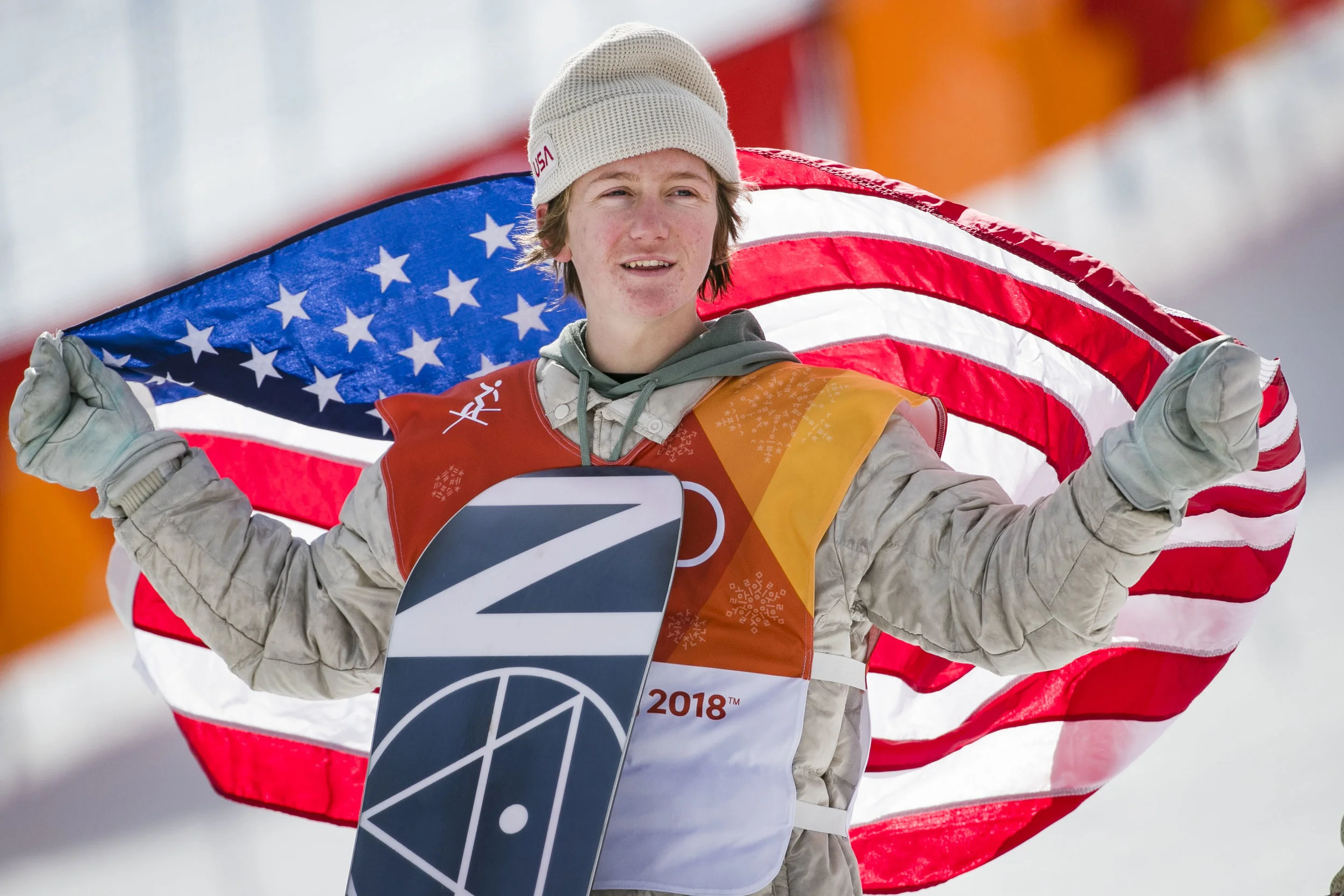 The first U.S. gold medal won by snowboard slopestyle 17-year-old Red Gerard, Feb. 11 at Phoenix Snow Park holds up an American flag during the medaling ceremony.