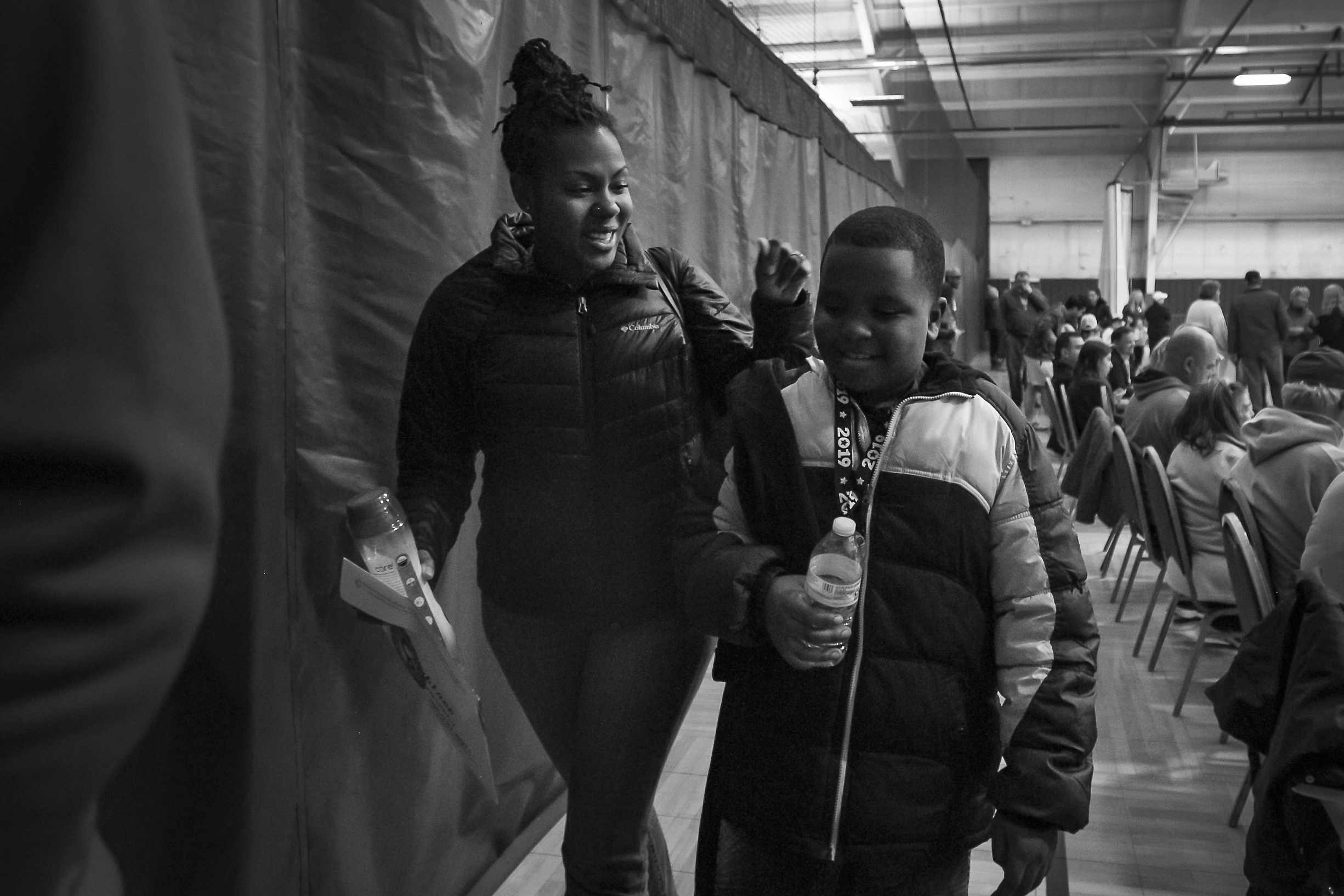  Walking out of the gym, Mia wraps her arm around her son and smiling, March 23, at the Northwest YMCA, Muncie, IN. When her son was still a toddler, Mia recalls winter approaching and worrying because she could not buy her son a winter coat. By usin