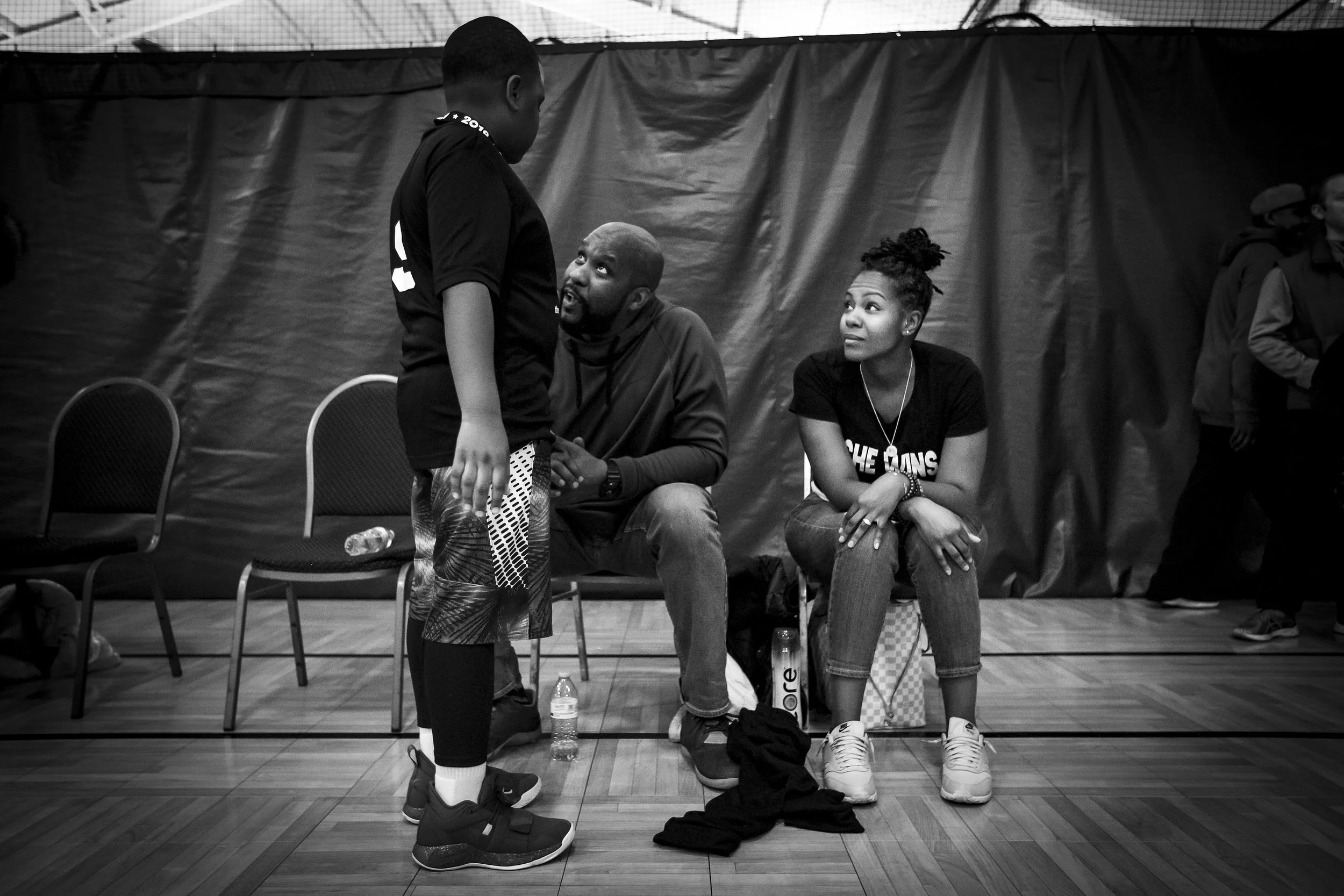 Dr. Mia Johnson (right) sits next to her husband while her talks to their 10-year-old son after his basketball game, March 23, at the Northwest YMCA, Muncie, IN. Dr. Johnson recalls the day she found out she was pregnant. She was standing in target 
