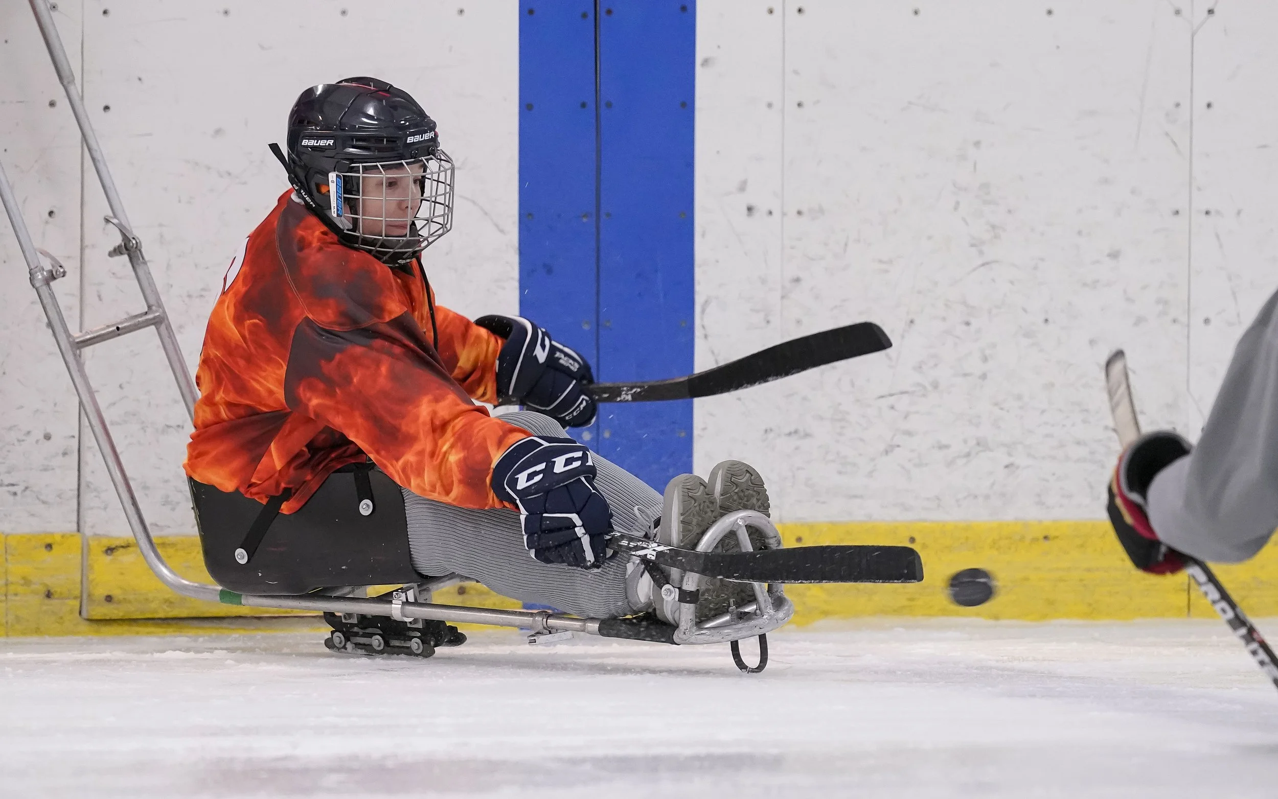  Marie Harman hits the puck across the ice during an Indy Steel sled hockey scrimmage on January 22, 2022, at Perry Park in Indianapolis. 