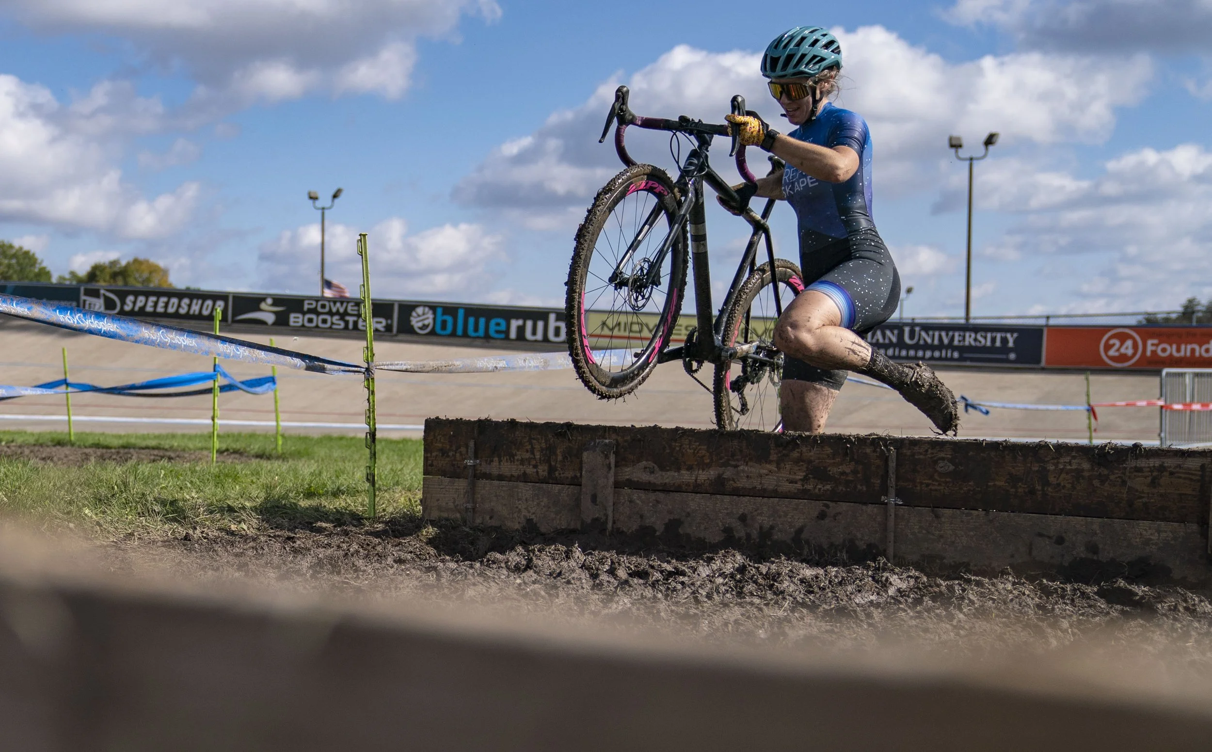  A cyclist jumps over a barricade during the Major Taylor Cyclocross Cup race Sunday, Oct. 31, 2021, at the Indy Cycloplex on Cold Spring Road, in Indianapolis. 