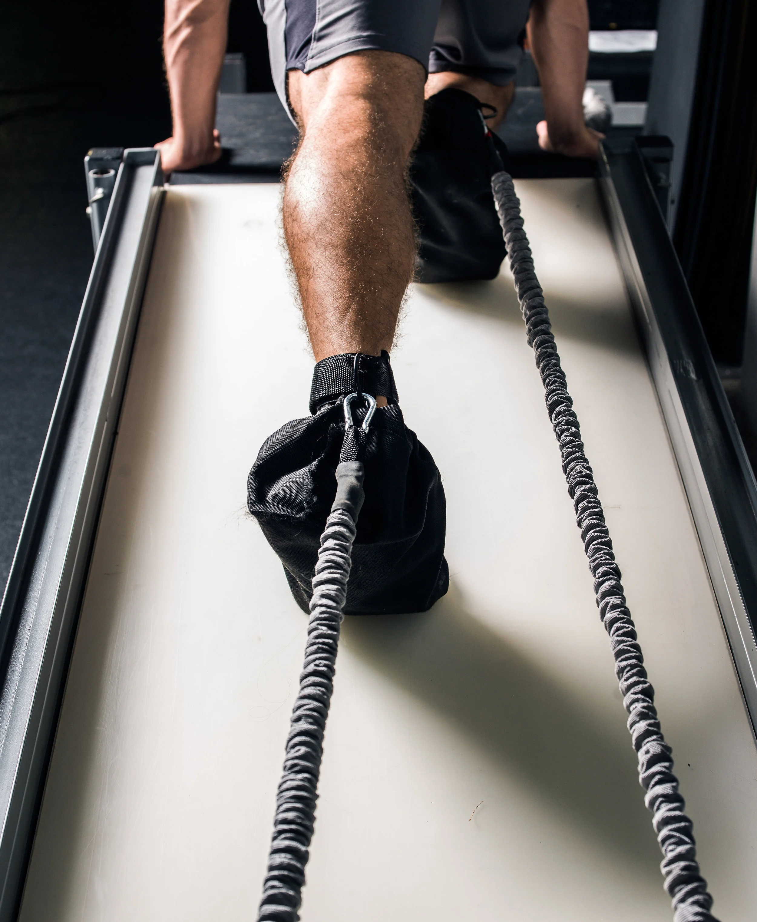 Mountain climbers on turbo ramp with resistance bands around ankles