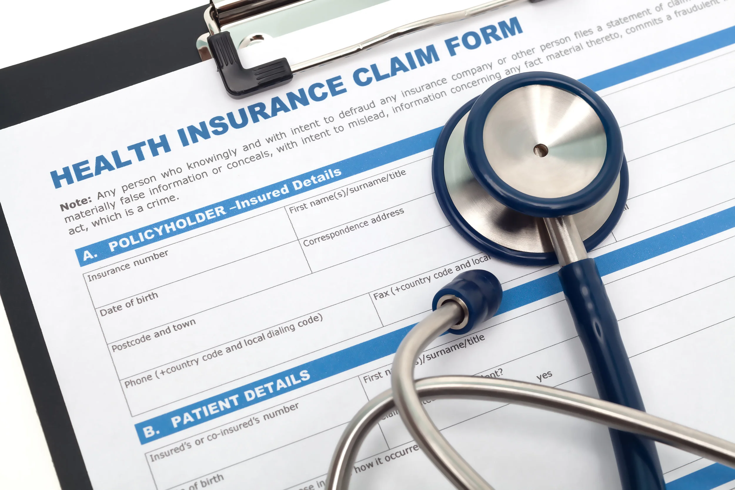 Blank copy of Insurance Claim Form for Physicians on clipboard with stethoscope overlayed