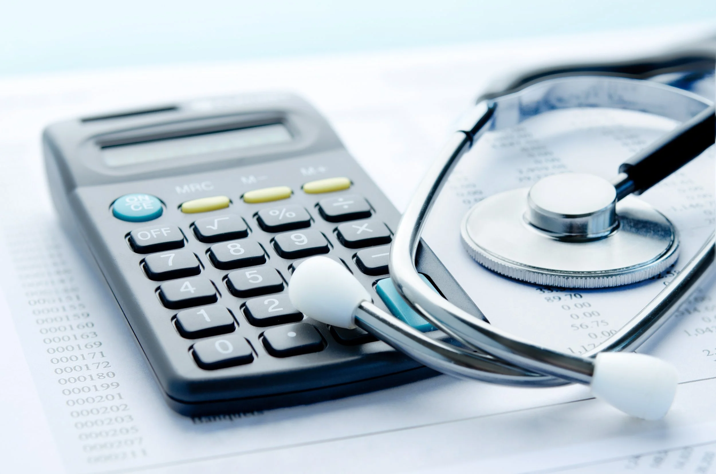 Calculator and stethoscope overlayed on sheets of paper filled with numbers, symbolizing expensive healthcare costs