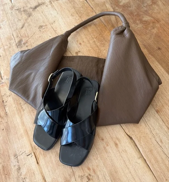 black strap sandals on brown handbag