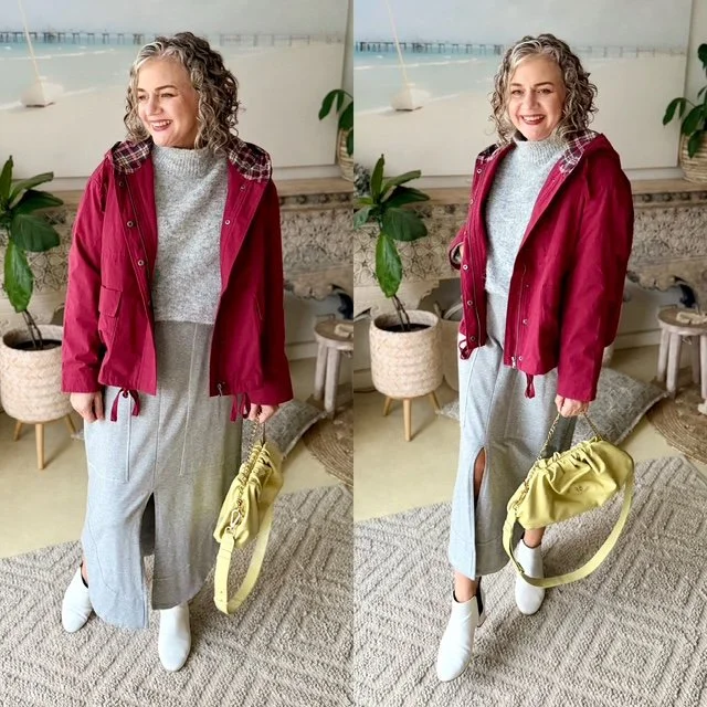women gray hair curly standing gray skirt gray knit jumper burgundy jacket lemon yellow handbag white boots