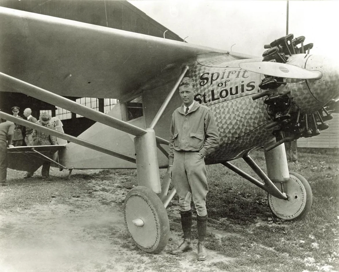 Charles Lindbergh standing beside the Spirit of St. Louis monoplane