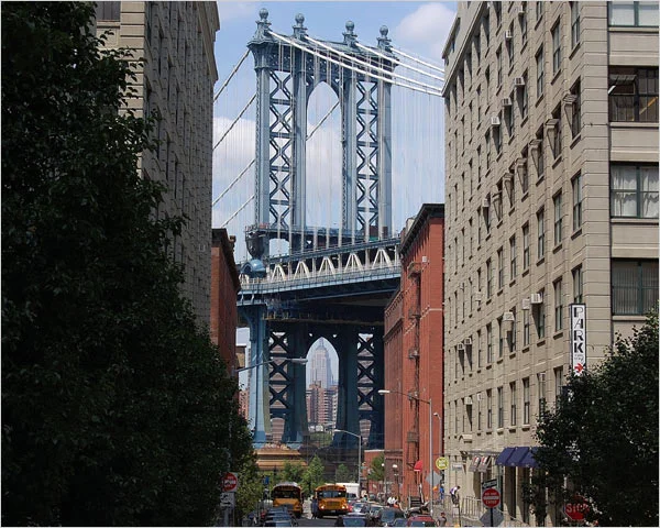 NYC's DUMBO Historic District with Manhattan Borough Bridge and the the Empire State building in the distance.