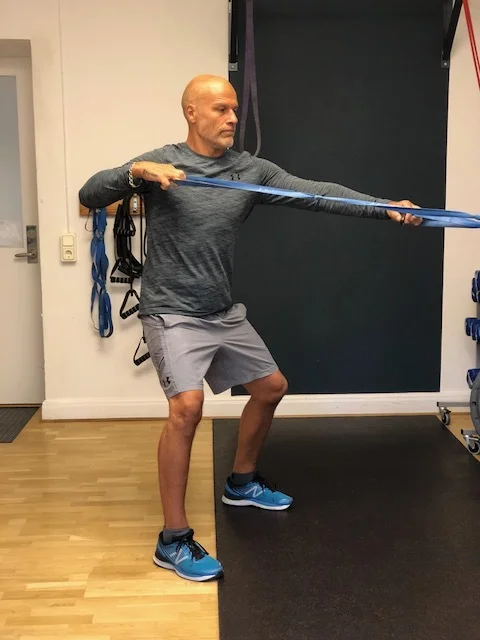 Ett band i varje hand. Vrid handen tills den när axeln, hög armbåge. Jämnt och rytmiskt.