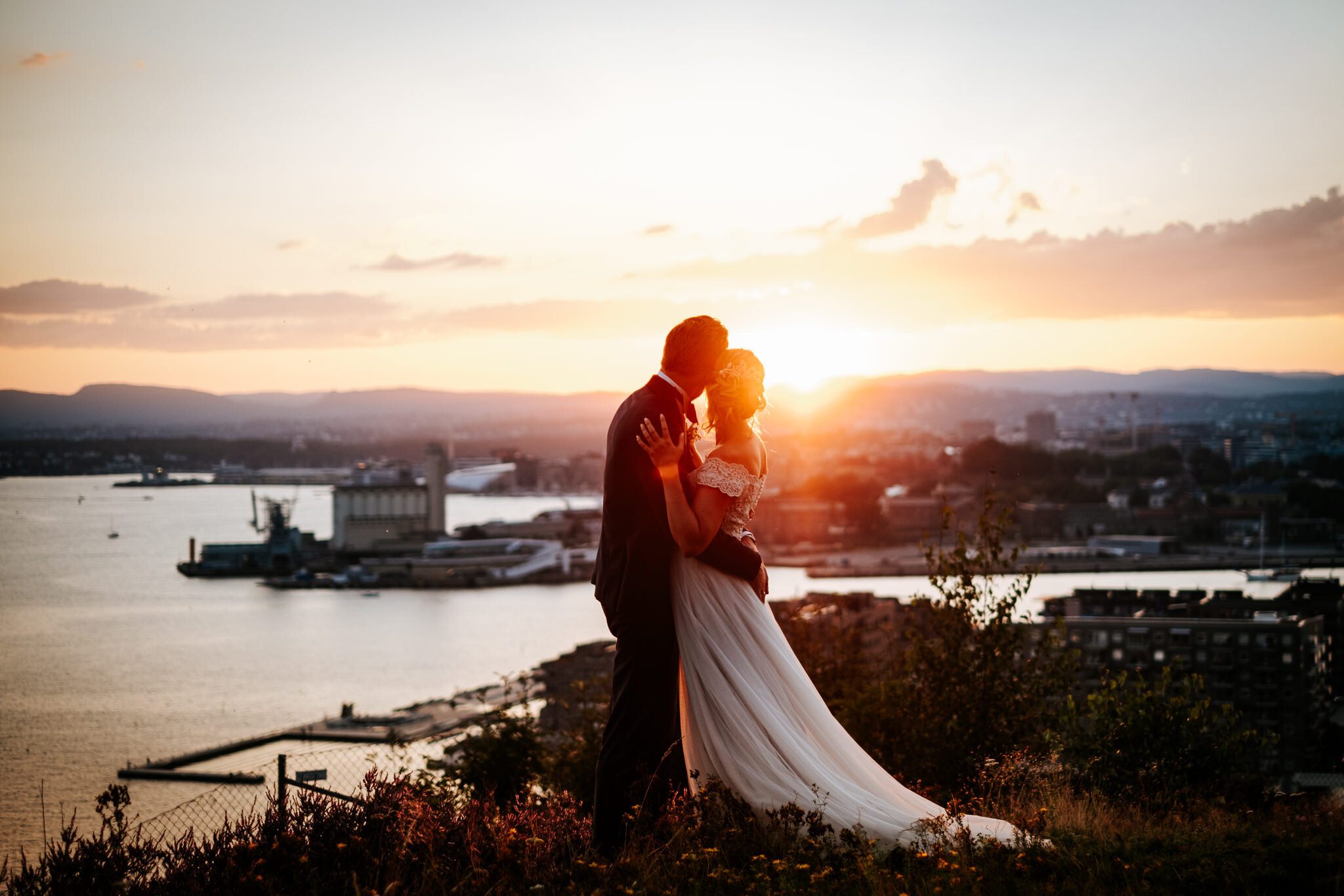  Lykken for en bryllupsfotograf er å akkurat rekke å ta noen bilder i det siste lyset før sola går ned. Oslo “skyline” leverer en vakker bakgrunn for Julie og André som giftet seg med sine nærmeste på Karlsborg spiseforretning på Ekeberg. 