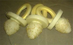Edible Pacifiers... Available in the color of your baby shower theme.... Can be displayed on a platter or individually boxed as a party favor.