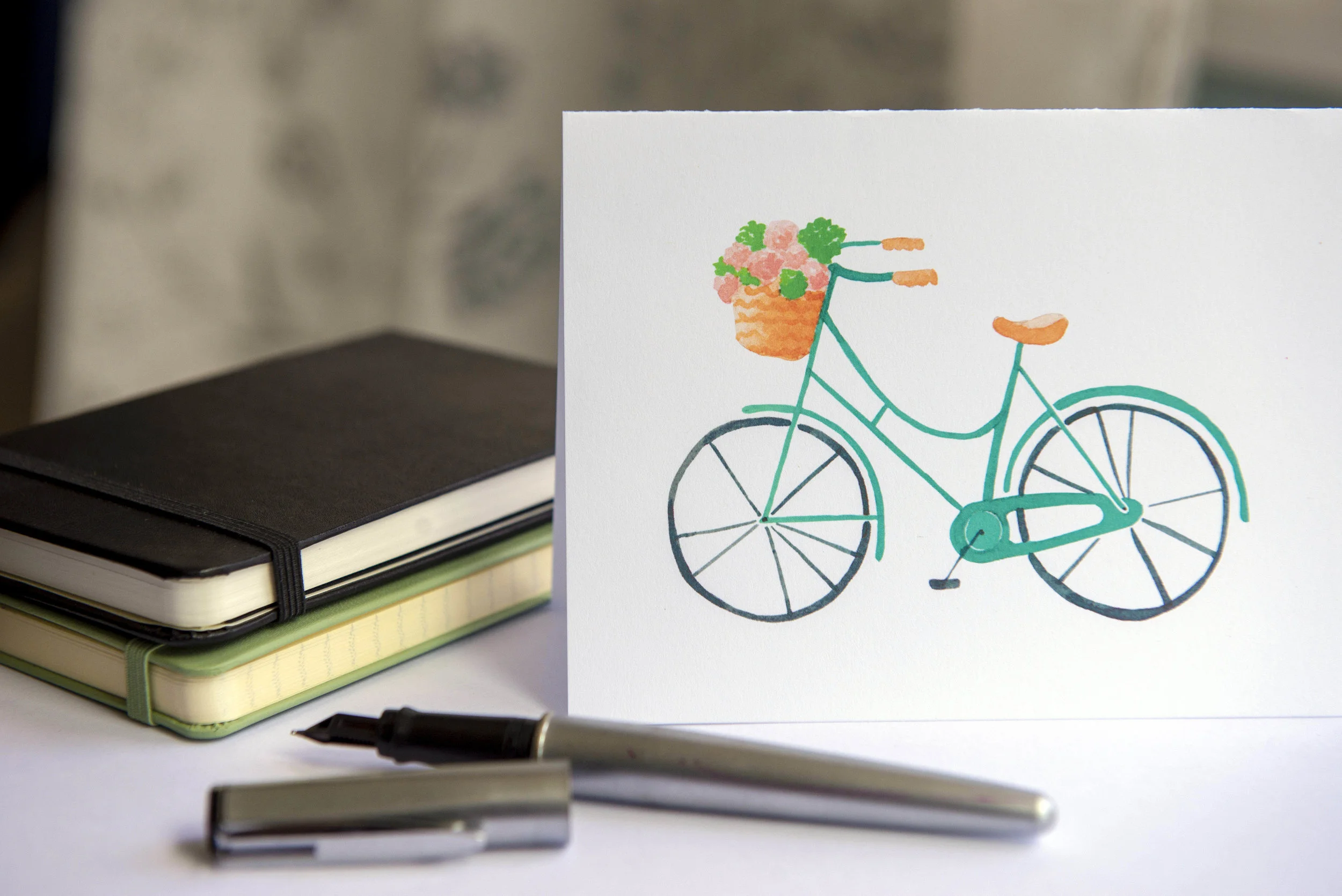 Printable watercolor greeting card featuring a vintage blue bicycle with a flower basket. Download once and print again and again!  Prints (2) cards per 8.5x11 inch paper. 
