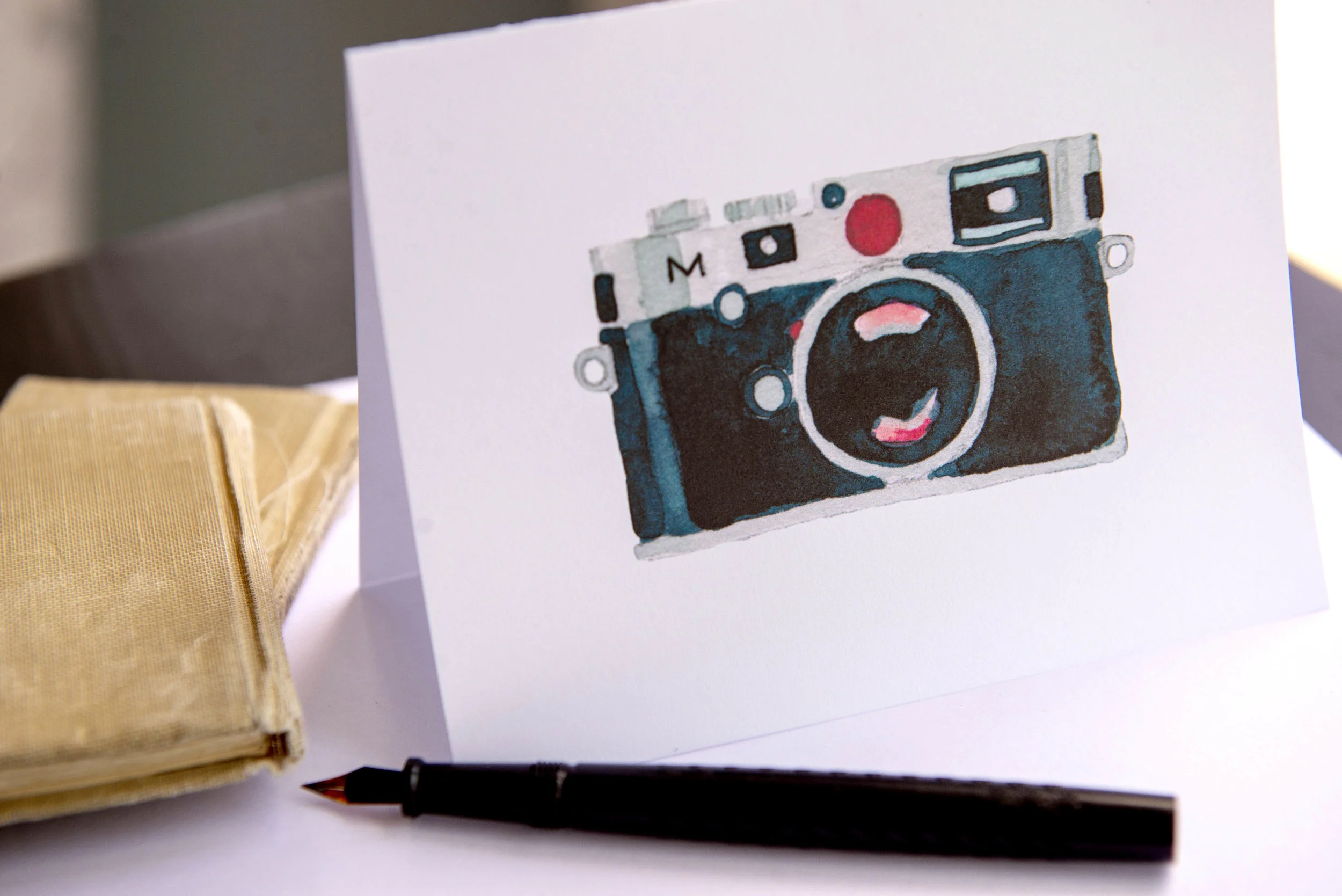 Printable watercolor greeting card featuring a black Leica film camera. Download once and print again and again!  Prints (2) cards per 8.5x11 inch paper. 