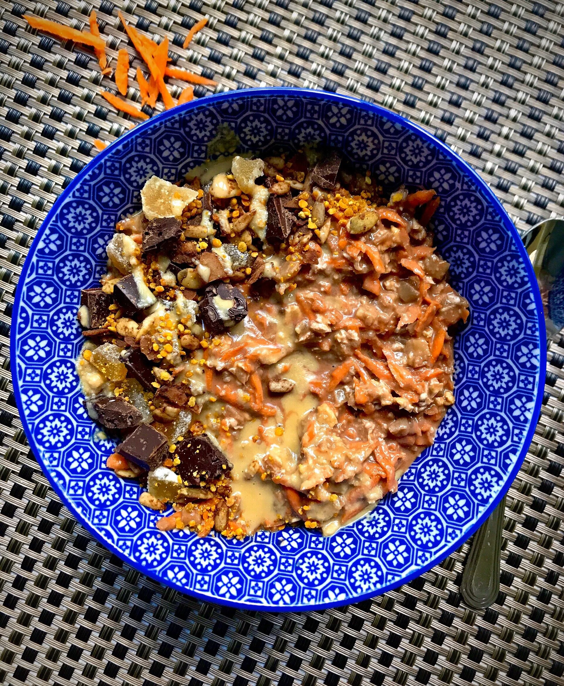 Chocolate Carrot Cake Overnight Oats topped with candied ginger, Giddy Yo 72% cacao Moka Crunch bar, granola, bee pollen, and a drizzle of tahini.