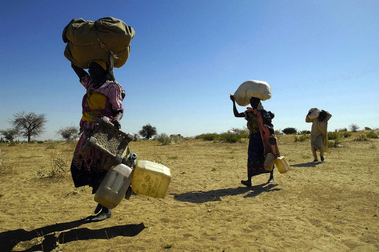 Refugees carrying belongings to trucks to be transfer from Himera, vicinity of Birak, to camp, 4 hours drive from there.