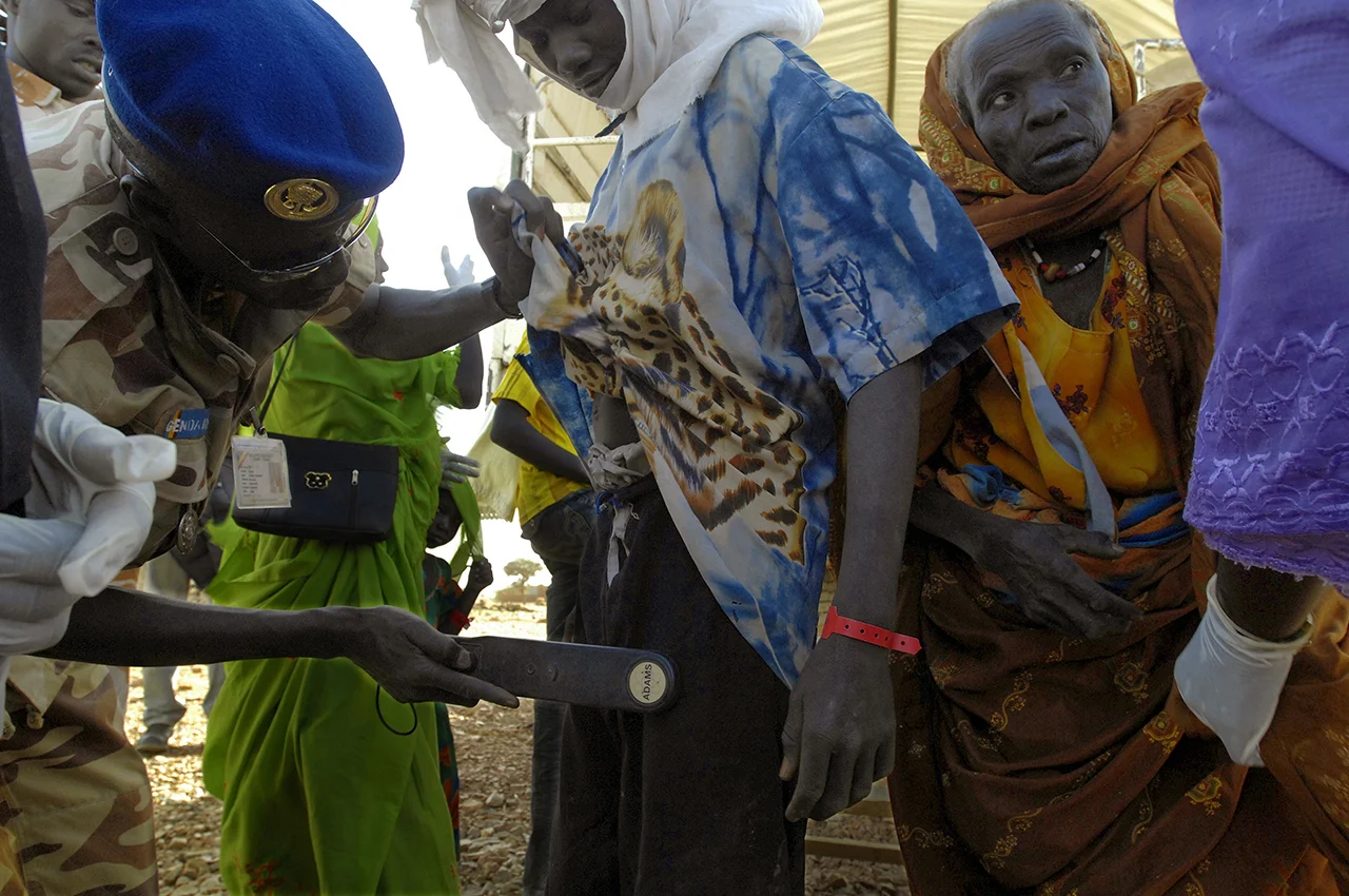 Getting down from the truck which transfer him from Birak, a young refugee is searched by the chadian police who is looking for weapons or ammunitions. 