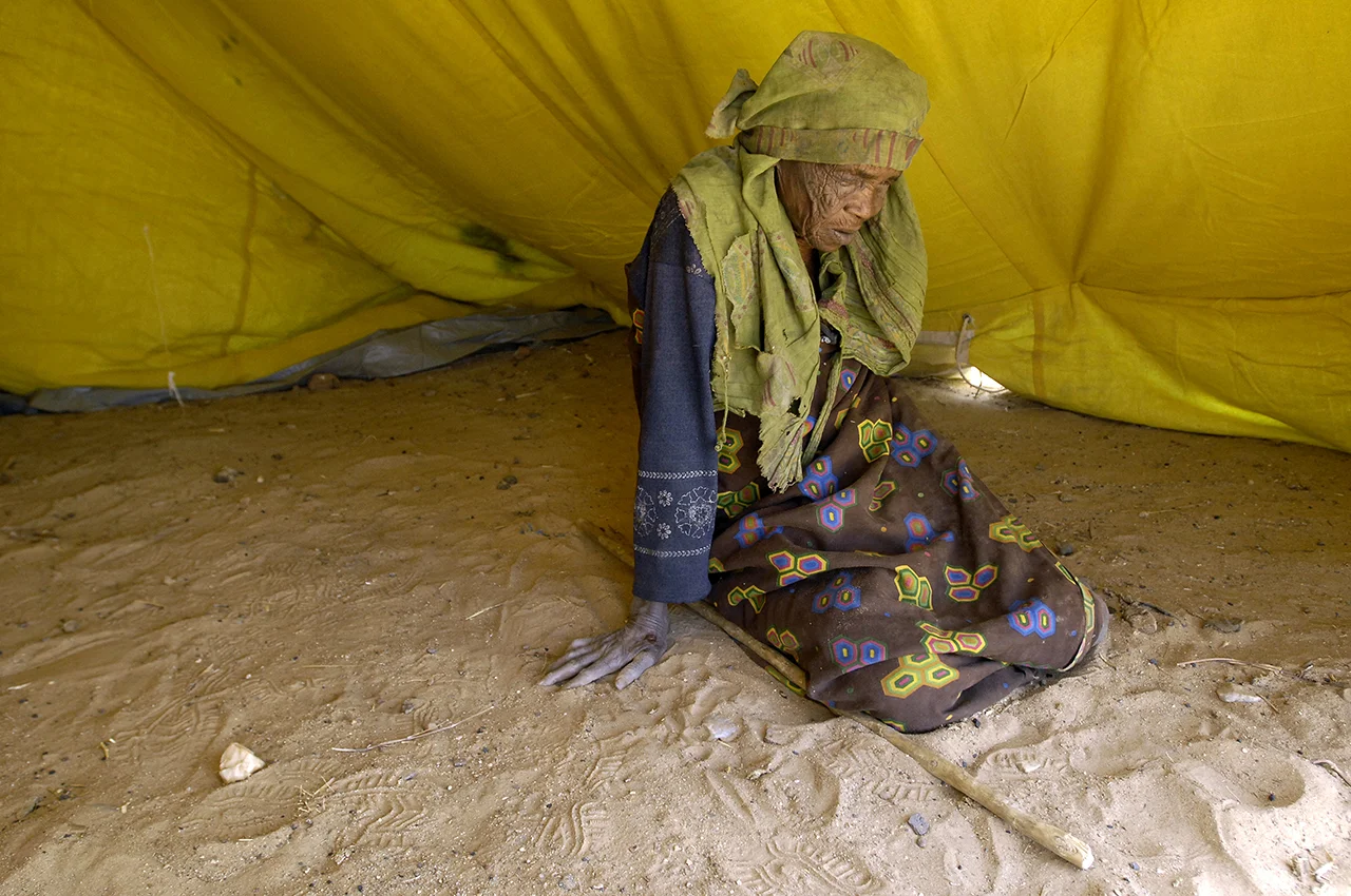 An old, blind refugee in her tent in Kounoungo camp. 