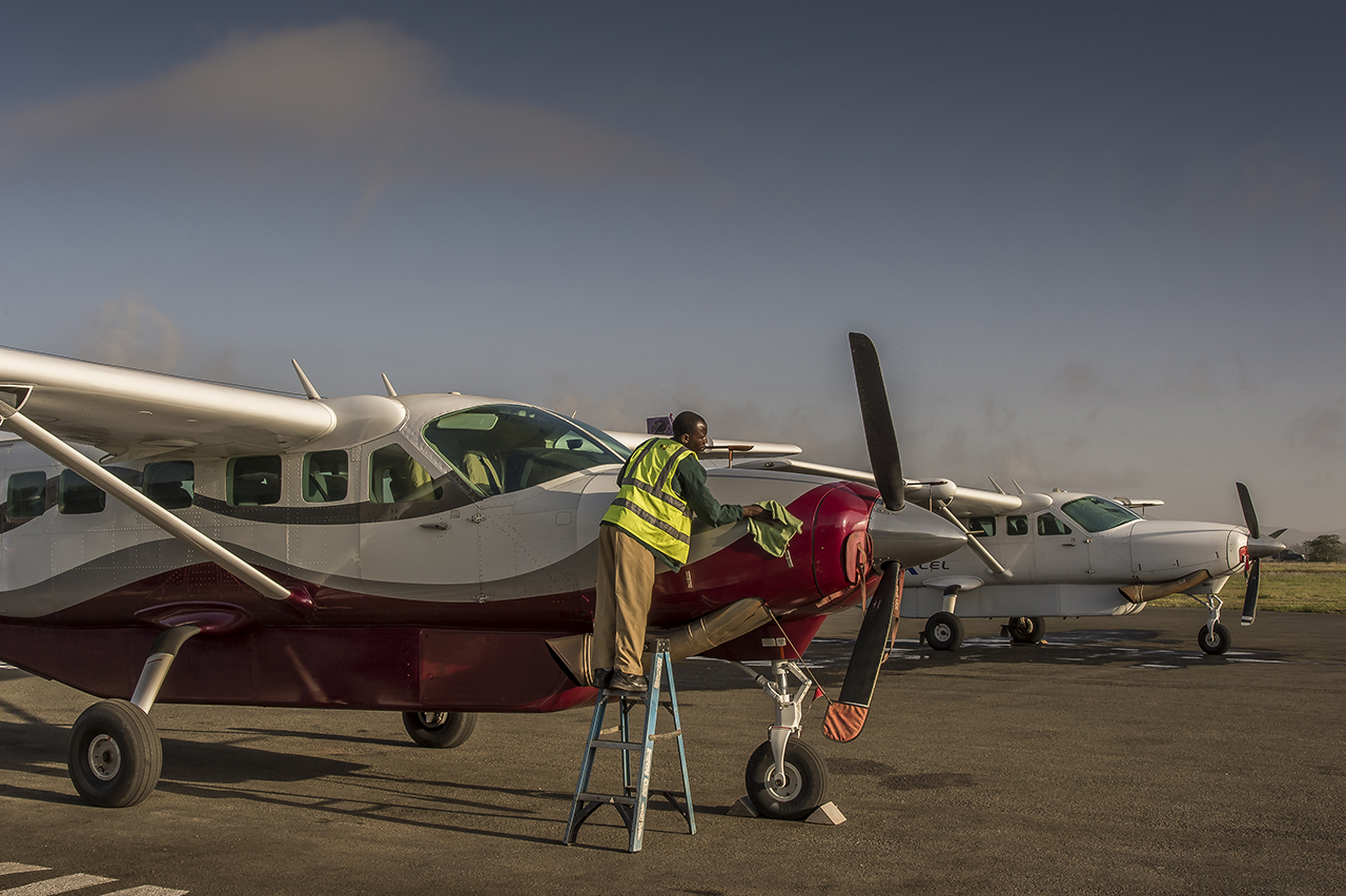 Early morning on Arusha airstrip, in northern Tanzania. A maintenance technician prepares a Cessna Grand Caravan, for its first morning flight to the airstrip of Seronera, an hamlet of few houses located in the heart of Seregenti National Parc, in T