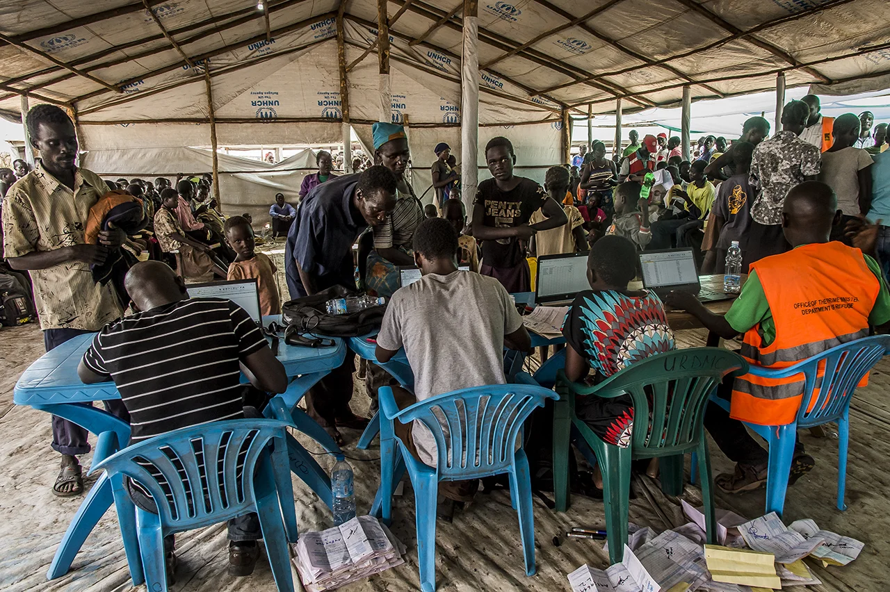 Officials from the Ugandan Prime Minister's Office consult the families' profiles to give them the appropriate piece of land (depending on the size of the family) where they will settle in the Bidibidi camp.