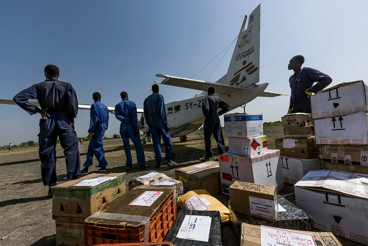 On the small aerodrome of Old Fangak, at the end of the runway, a strip of land, impassable during the rainy season, Nuers paid for the task, unload the cargo of a small plane, for the benefit of an NGO. The town of Old Fangak is located along the Phow River (Zaraf, giraffe in Arabic), a tributary of the White Nile, in Jonglei State, 100 km south of Malakal. No roads. Only accessible by boat or small plane.